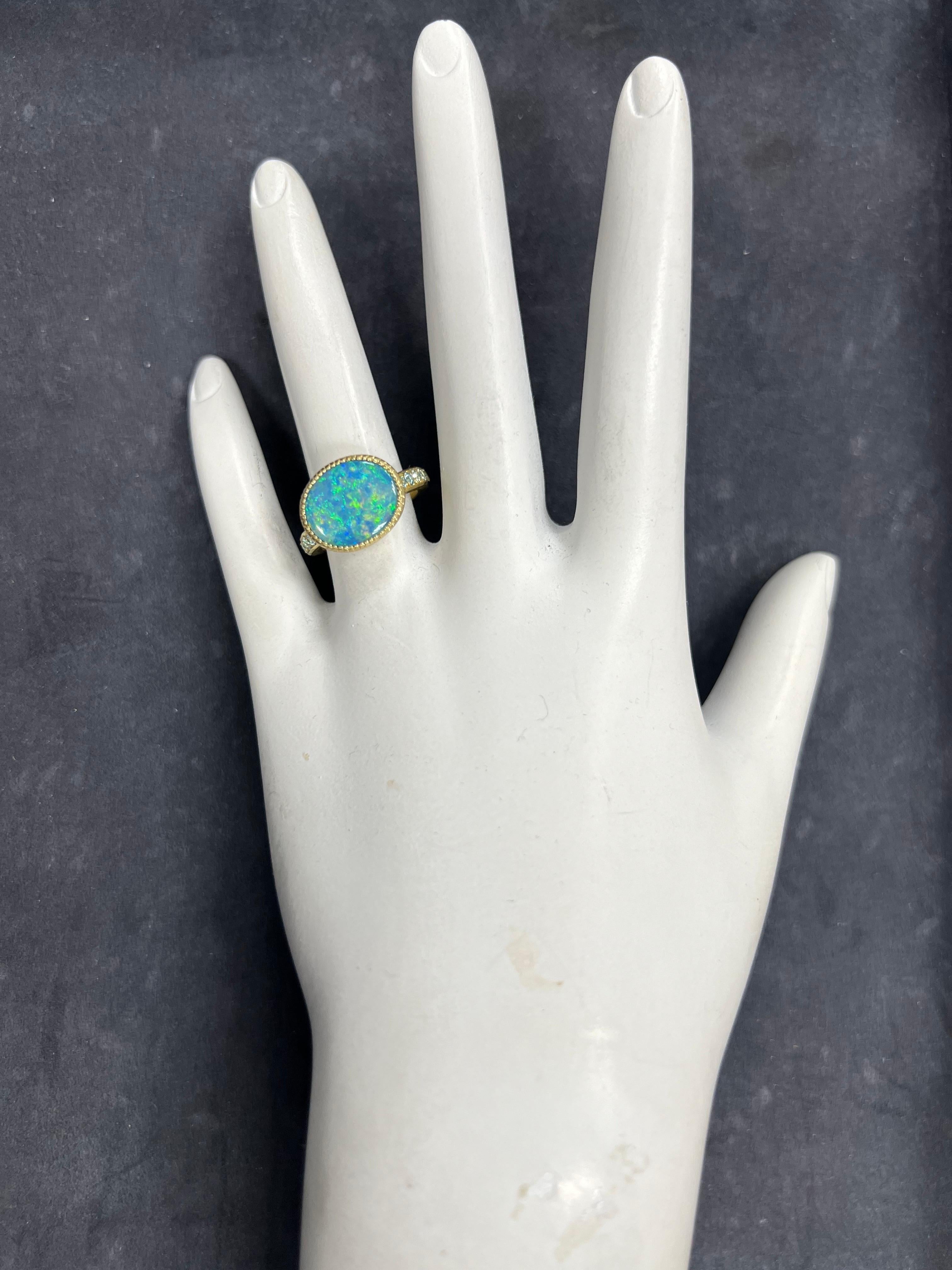 Un magnifico anello in oro 18k con doppio Opale australiano a cresta di luce. La fascia ha uno spessore di 2,8 mm ed è incastonata con dieci zirconi blu. L'anello è una misura 5,5, il peso totale è di 7,5 grammi. 