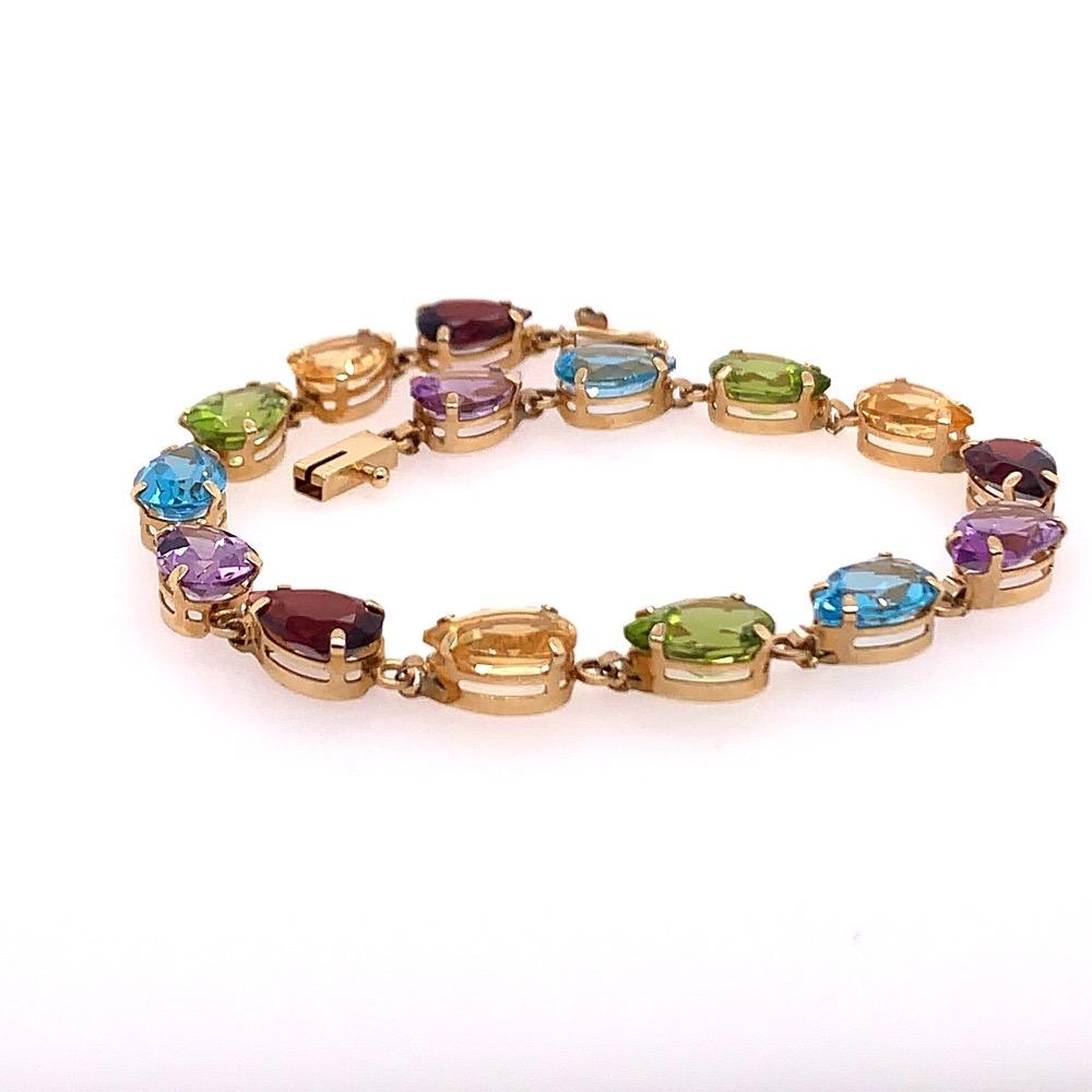 A stunning modern 10k gold bracelet set with multiple color pear shaped gem stones measuring approximately 9x6mm. 

Included are natural Topaz Quartz, Amethyst Quartz, and Garnets. 

The weight of the piece is 7.8 grams. 
