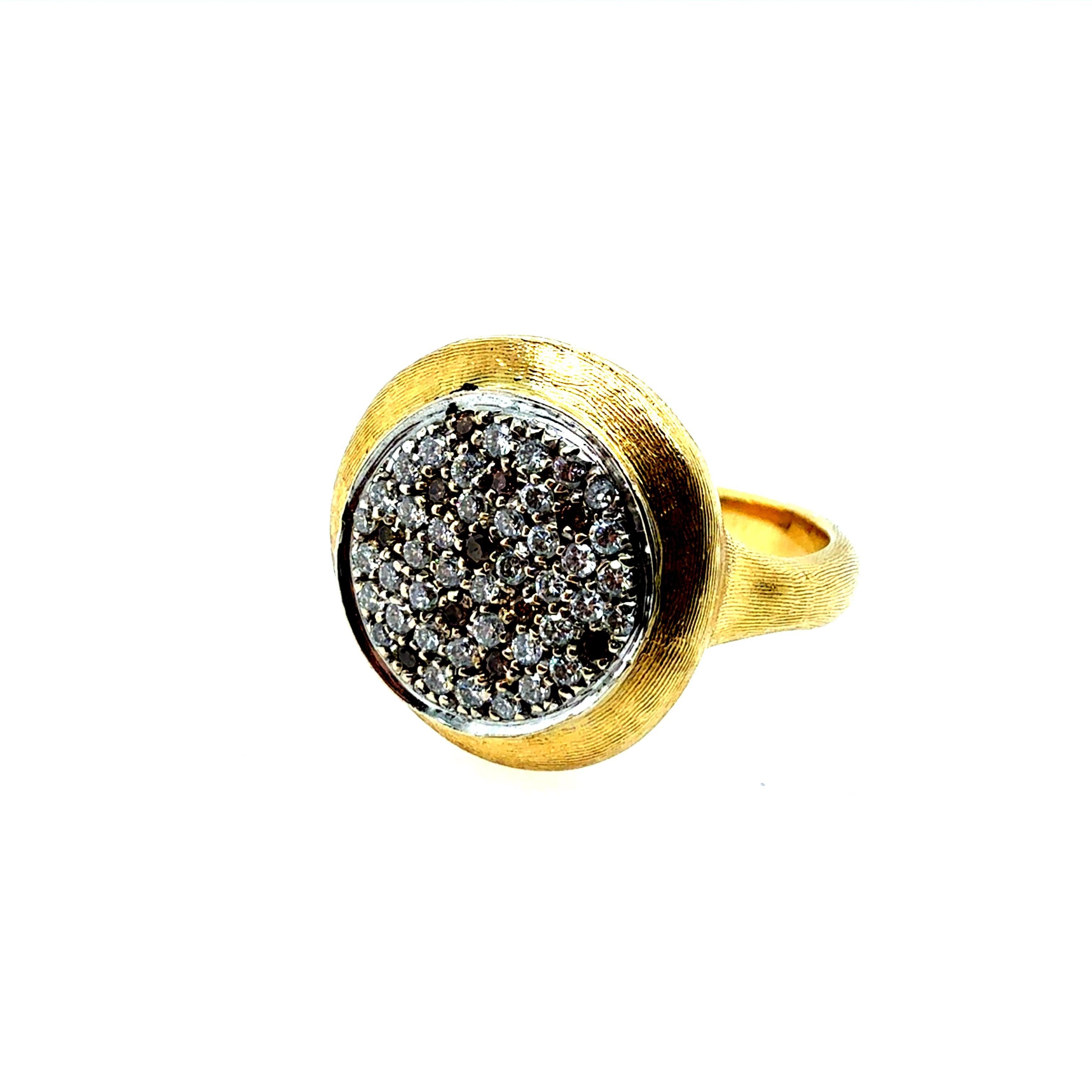 Made in Italy by Marco Bicego, this 18K yellow gold ring features a satin finish and is stamped 750. Set with approximately 1 carat of natural colorless round brilliant diamonds accented by champagne diamonds, the band measures 3 mm wide and 15.5 mm