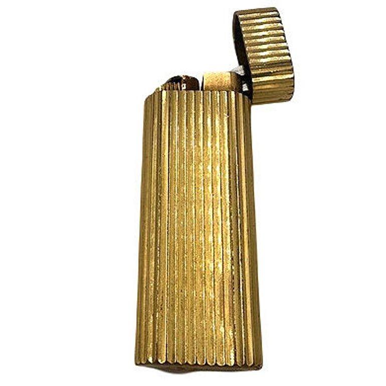 The Must de Cartier 18ct Gold Plated Lighter with a serial number of 60976E. Known for its elegant and high-quality accessories. The 