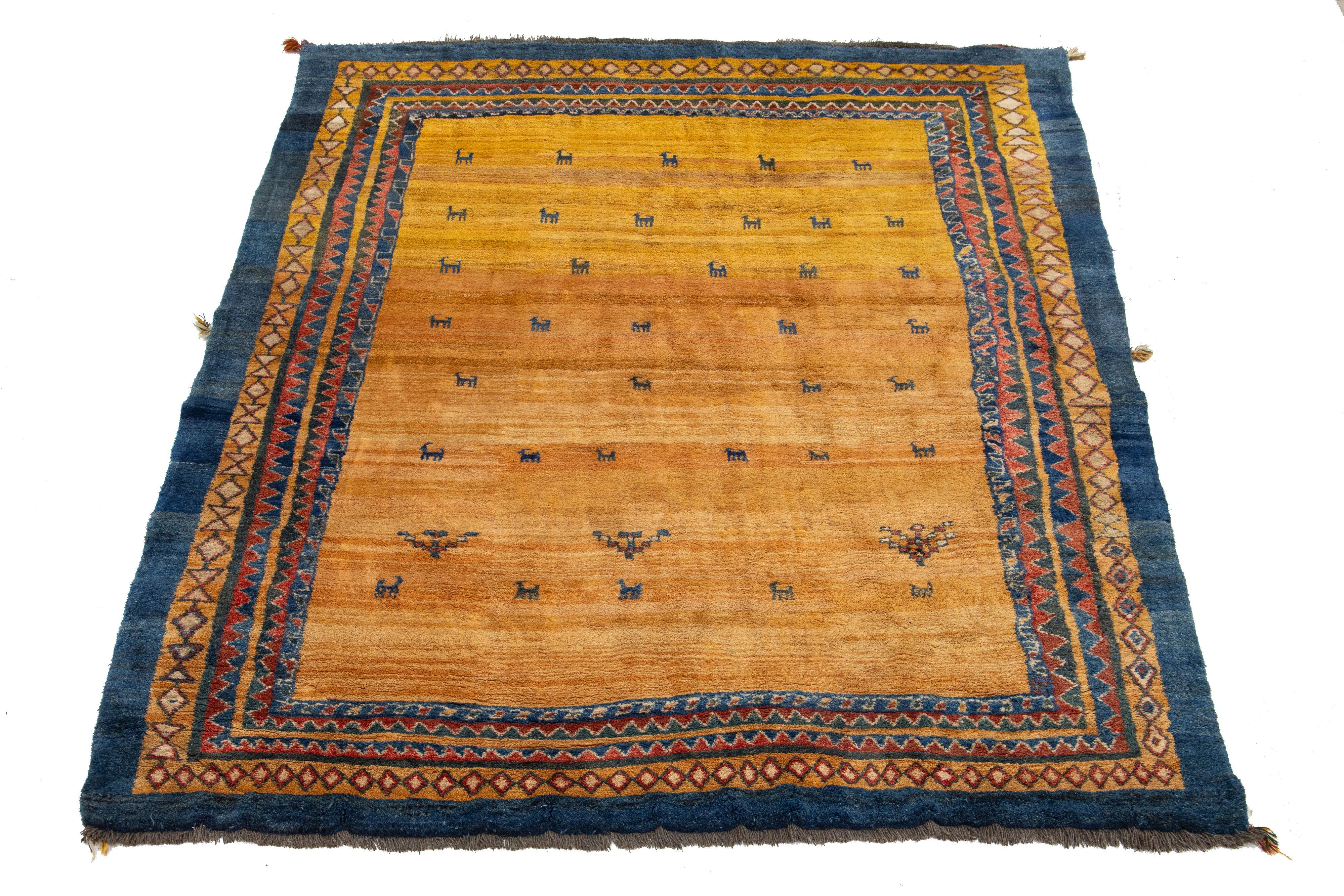 Dieser moderne Gabbeh-Teppich ist handgeknüpft und mit einem modernen geometrischen Muster versehen. Der Sockel aus Goldrute ist mit roten und blauen Details akzentuiert.

Dieser Teppich misst 10'5