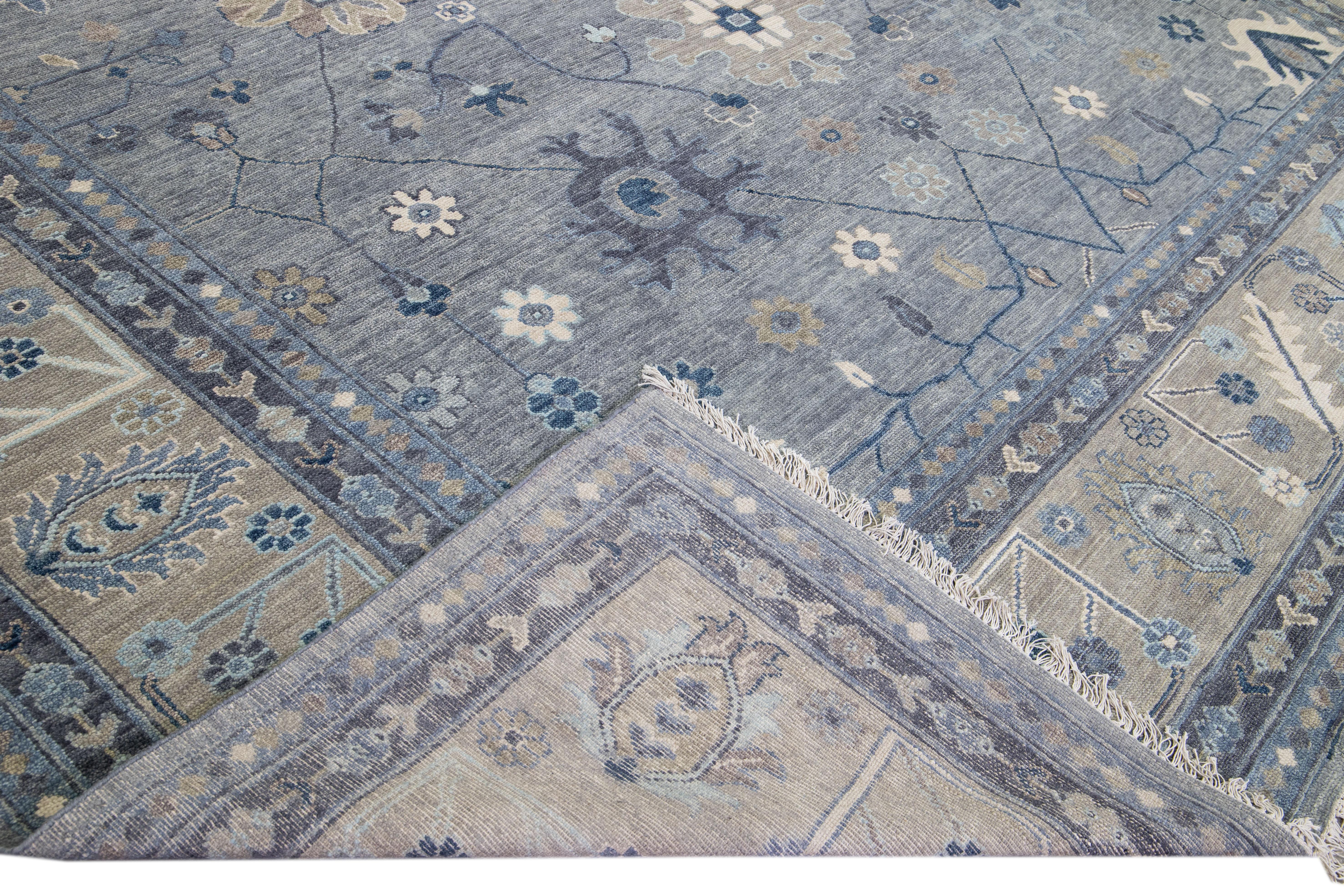 Beautiful modern Oushak hand-knotted wool rug with a gray field. This Oushak rug has a beige designed frame and blue accents all over a gorgeous floral design.

This rug measures 13' x 15'.

Our rugs are professional cleaning before shipping.