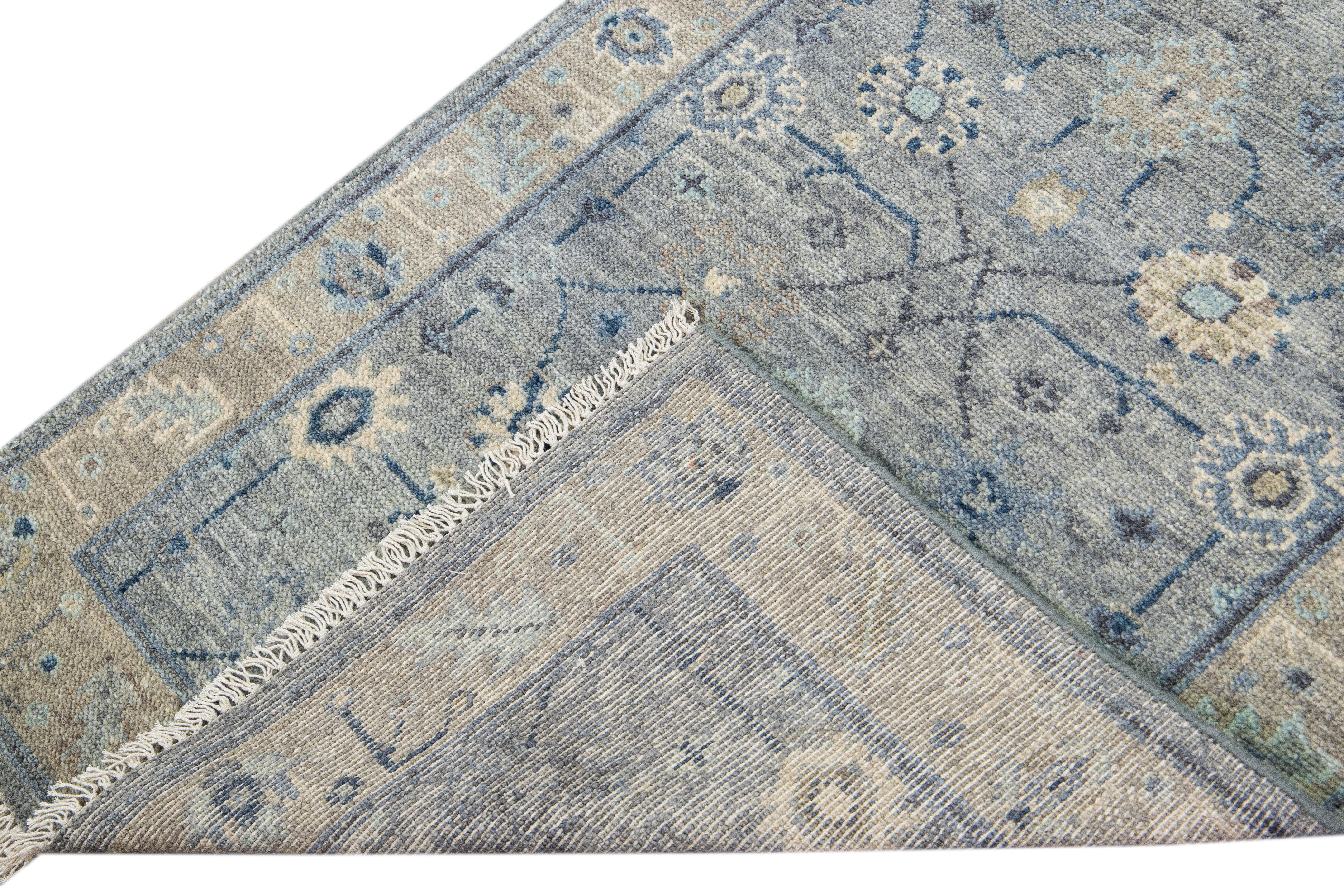 Beautiful modern Oushak hand-knotted wool runner with a gray field. This Oushak rug has a beige designed frame and blue accents all over a gorgeous floral design.

This rug measures 3'1