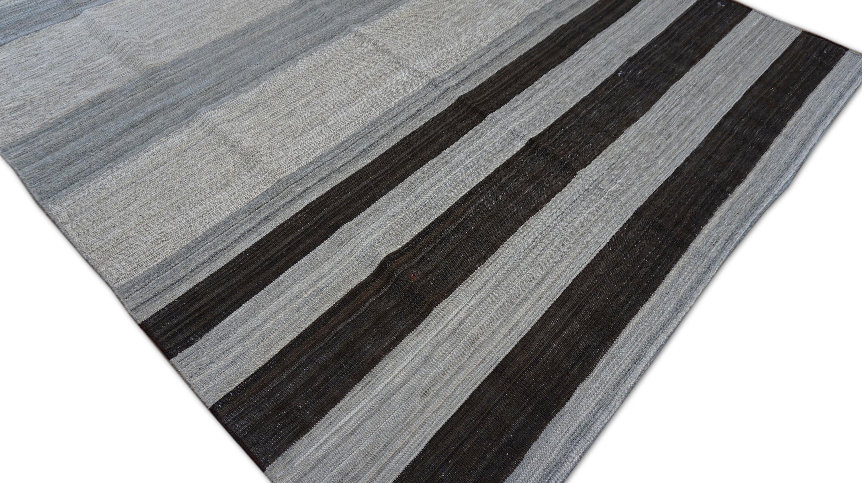 Dieser moderne, handgeknüpfte Wollteppich bietet ein raffiniertes und zurückhaltendes Design, das auf fachmännischer Handwerkskunst beruht. Der Teppich zeichnet sich durch eine Reihe horizontaler Streifen in verschiedenen Anthrazit- und Grautönen