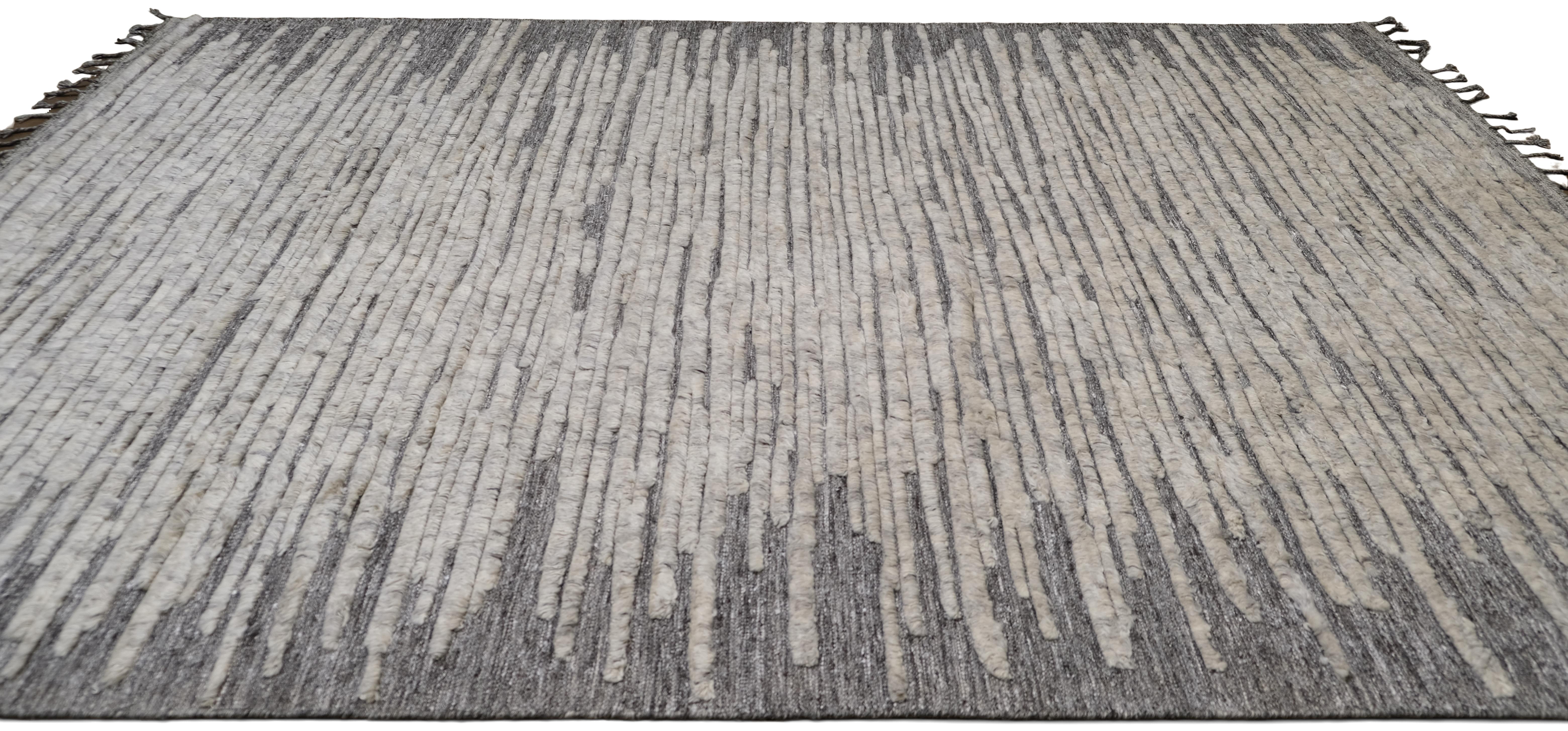Bringen Sie moderne Raffinesse in Ihren Raum mit diesem exquisiten handgeknüpften Wollteppich mit abstraktem, linearem Muster. Das kontrastreiche Muster aus unregelmäßigen elfenbeinfarbenen und grauen horizontalen Linien erzeugt einen visuell