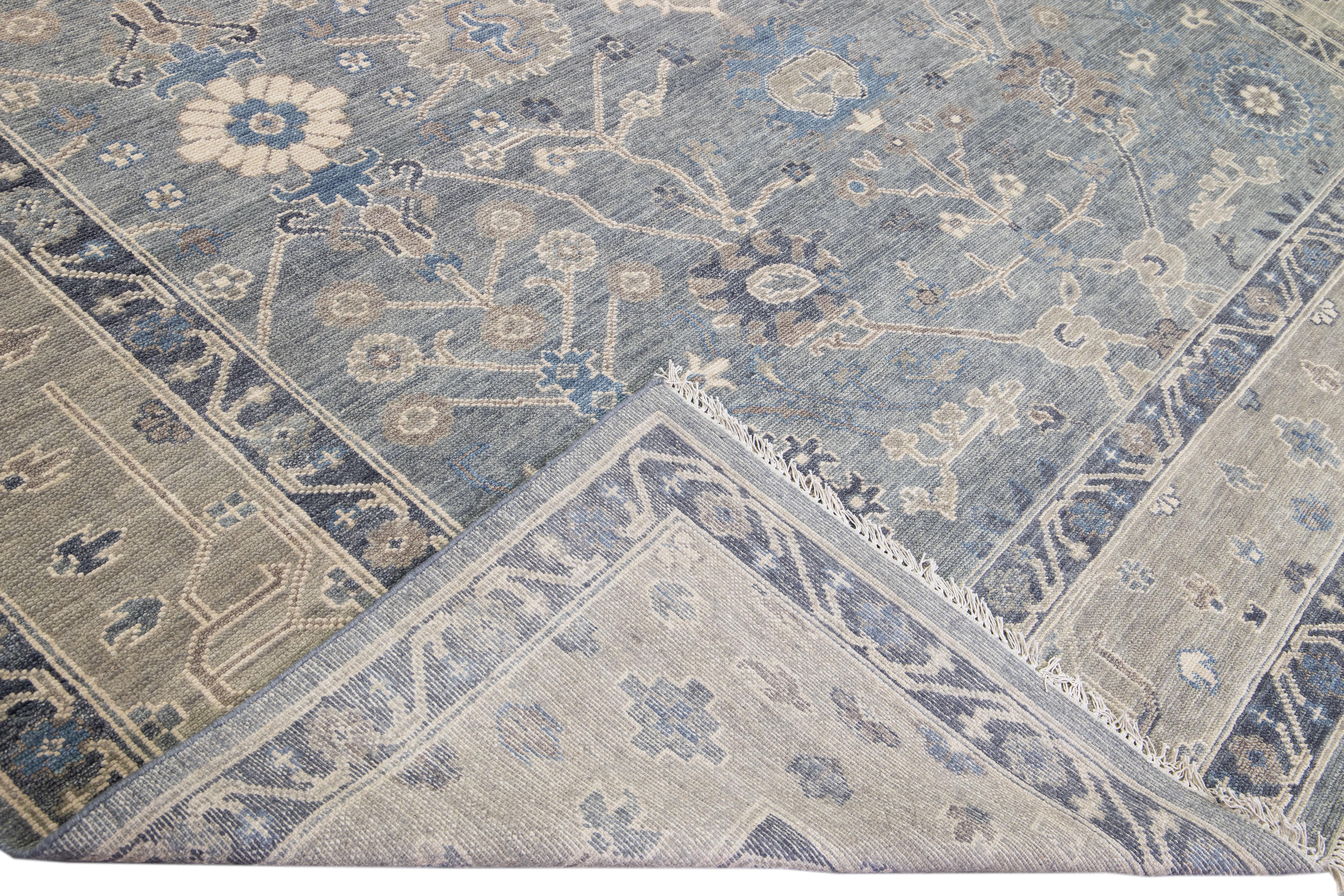 Beautiful modern Square Oushak hand-knotted wool rug with a gray field. This Oushak rug has a Tan-designed frame and blue accents all over a gorgeous floral design.

This rug measures 11' x 11'.

Our rugs are professional cleaning before