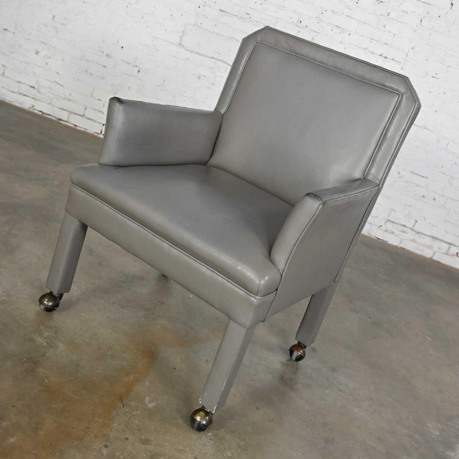 Fabulous modern gray faux leather modified Parson’s style armed accent chair on casters. Beautiful condition, keeping in mind that this is vintage and not new so will have signs of use and wear. There is a little wear to the vinyl on the tips and