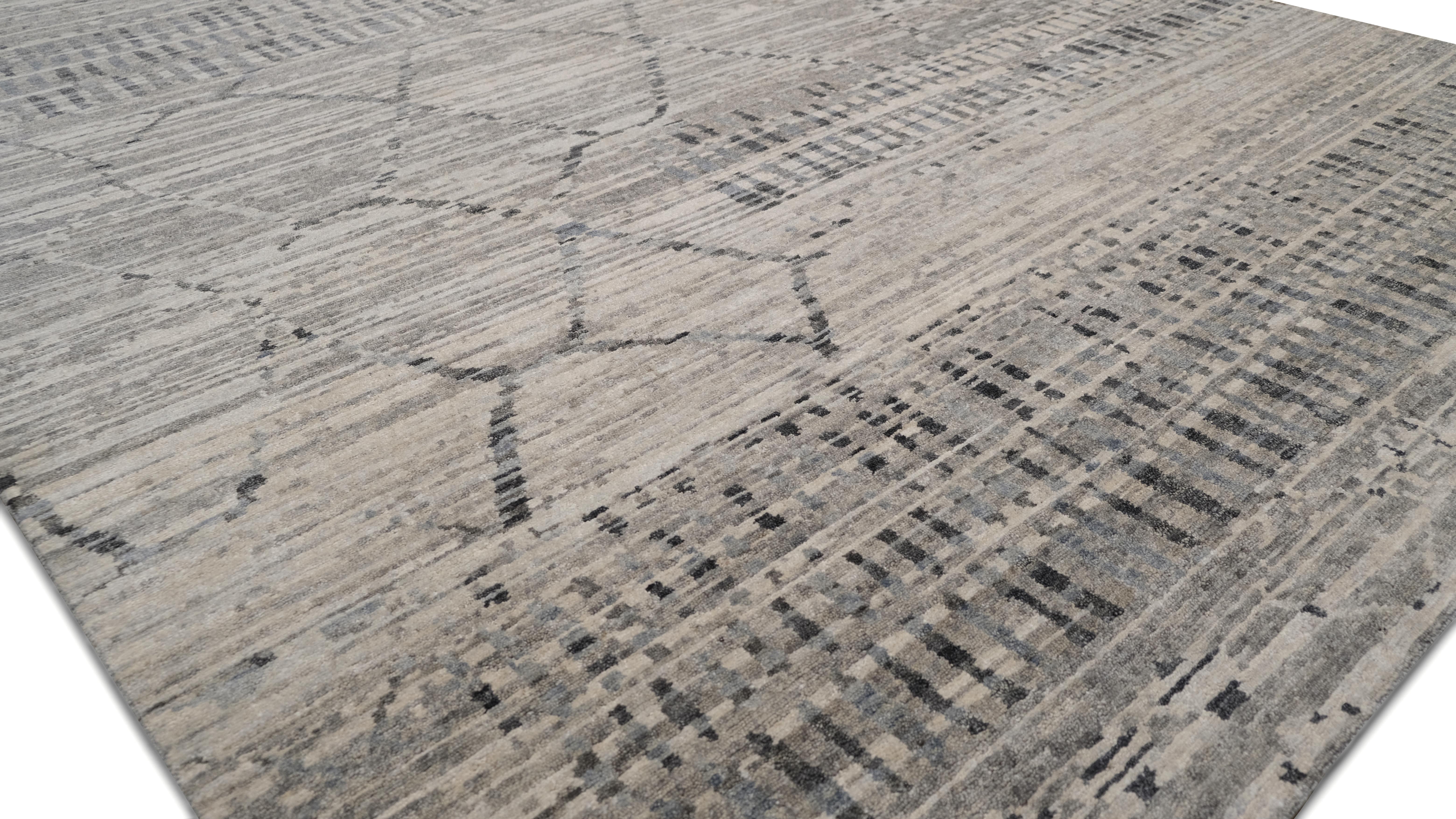 Découvrez la beauté artisanale de ce tapis en laine noué à la main, présentant un motif géométrique tribal moderne complexe dans une palette sophistiquée de gris et d'ivoire. La combinaison unique de motifs linéaires, de losanges et de motifs