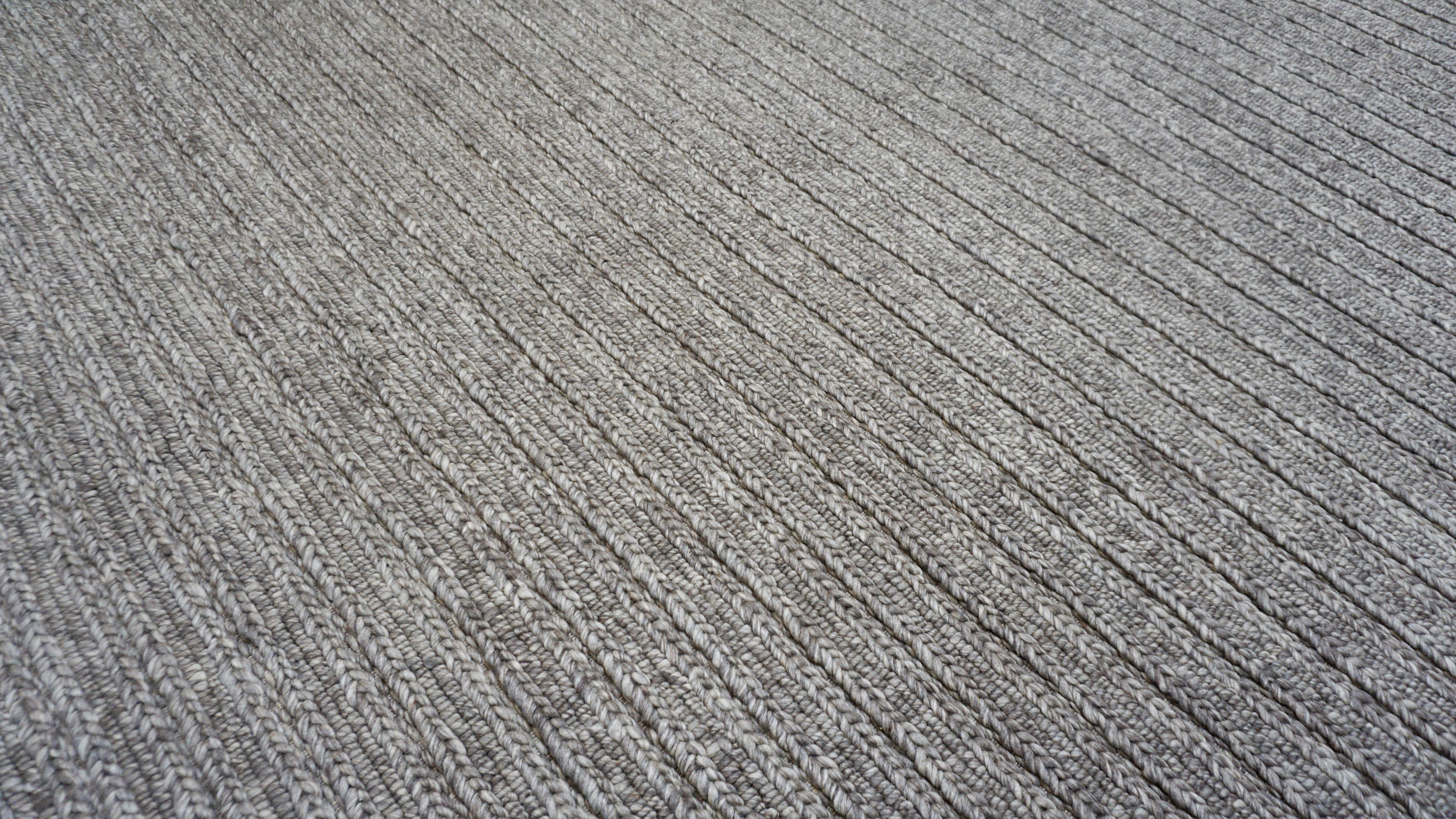 This modern hand-knotted wool rug offers a refined blend of texture, craftsmanship, and understated elegance. Meticulously woven by master artisans—the rug features a richly dimensional ribbed surface that adds both tactile depth and visual rhythm