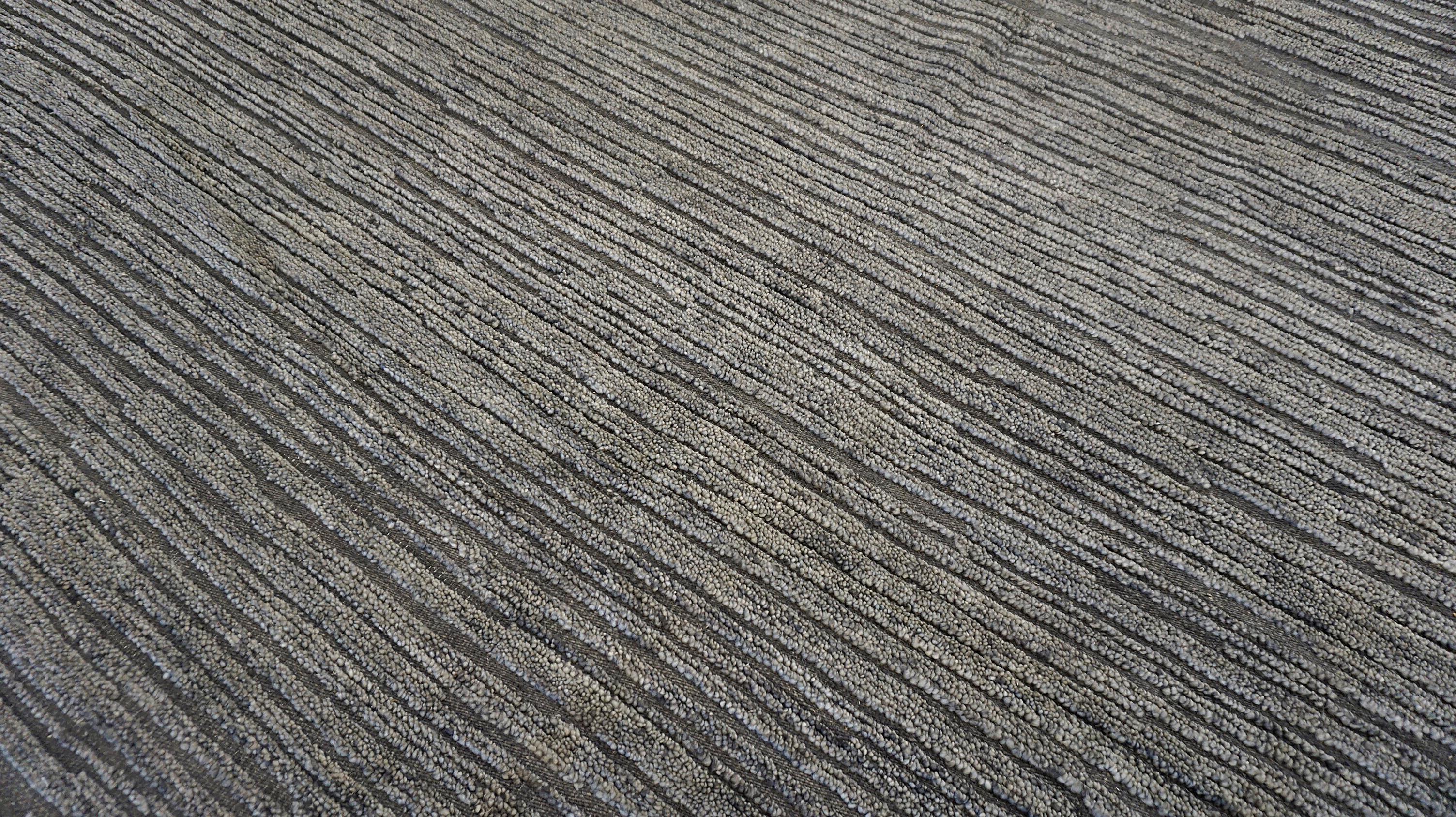 Questo tappeto in lana annodato a mano è un'espressione magistrale del minimalismo moderno, progettato per elevare gli interni contemporanei con la sua estetica elegante e sofisticata. La superficie del tappeto è realizzata in lana filata a mano,