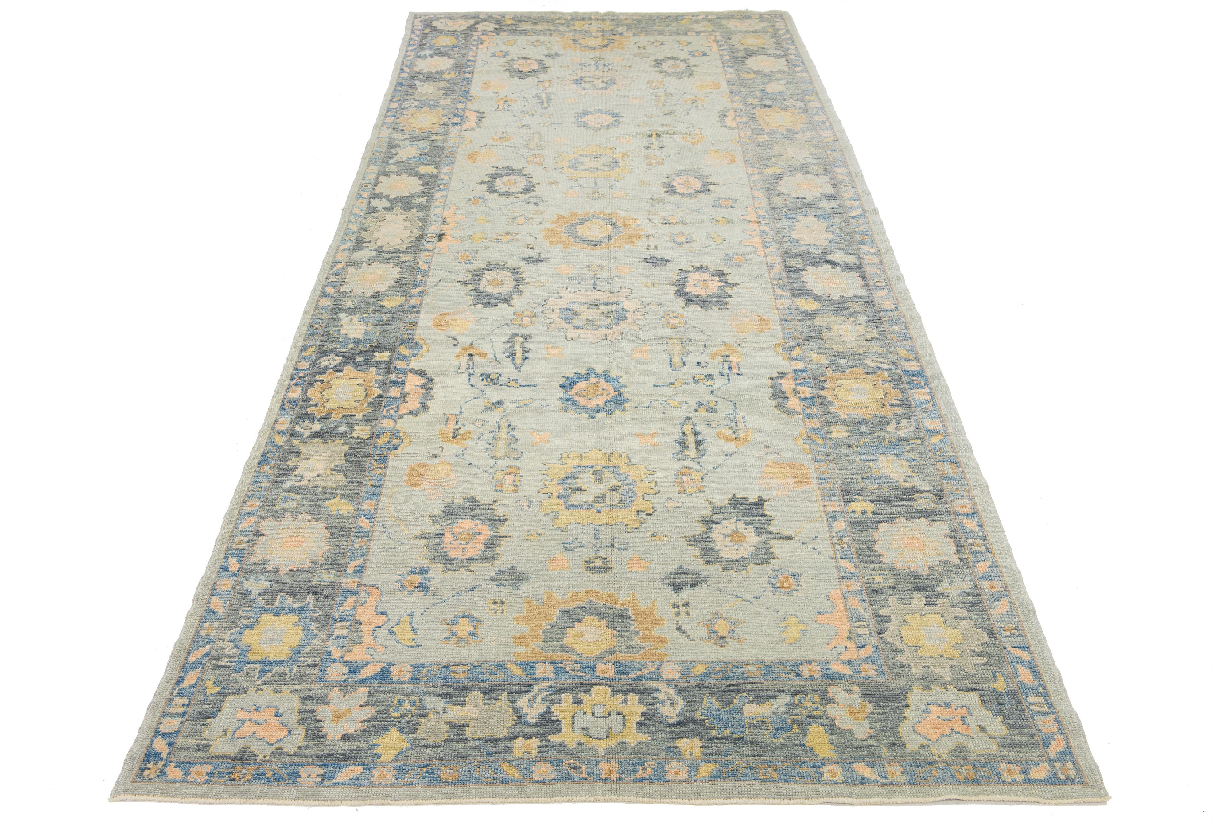 Beautiful modern Oushak hand-knotted wide wool rug with a gray field. This Oushak rug has multicolor accents all over a gorgeous geometric floral motif.

This rug measures 6'3