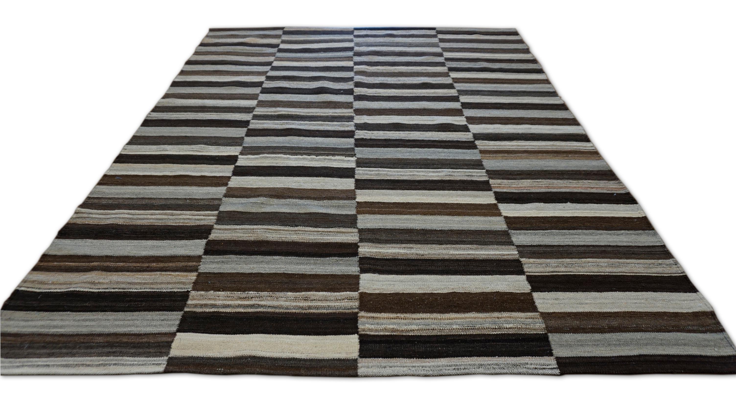 This flatweave wool rug brings a bold contemporary rhythm to any space with its charcoal, brown, and ivory each woven with subtle irregularities that reflect its artisanal roots.

The visual contrast of dark and light hues arranged in a structured