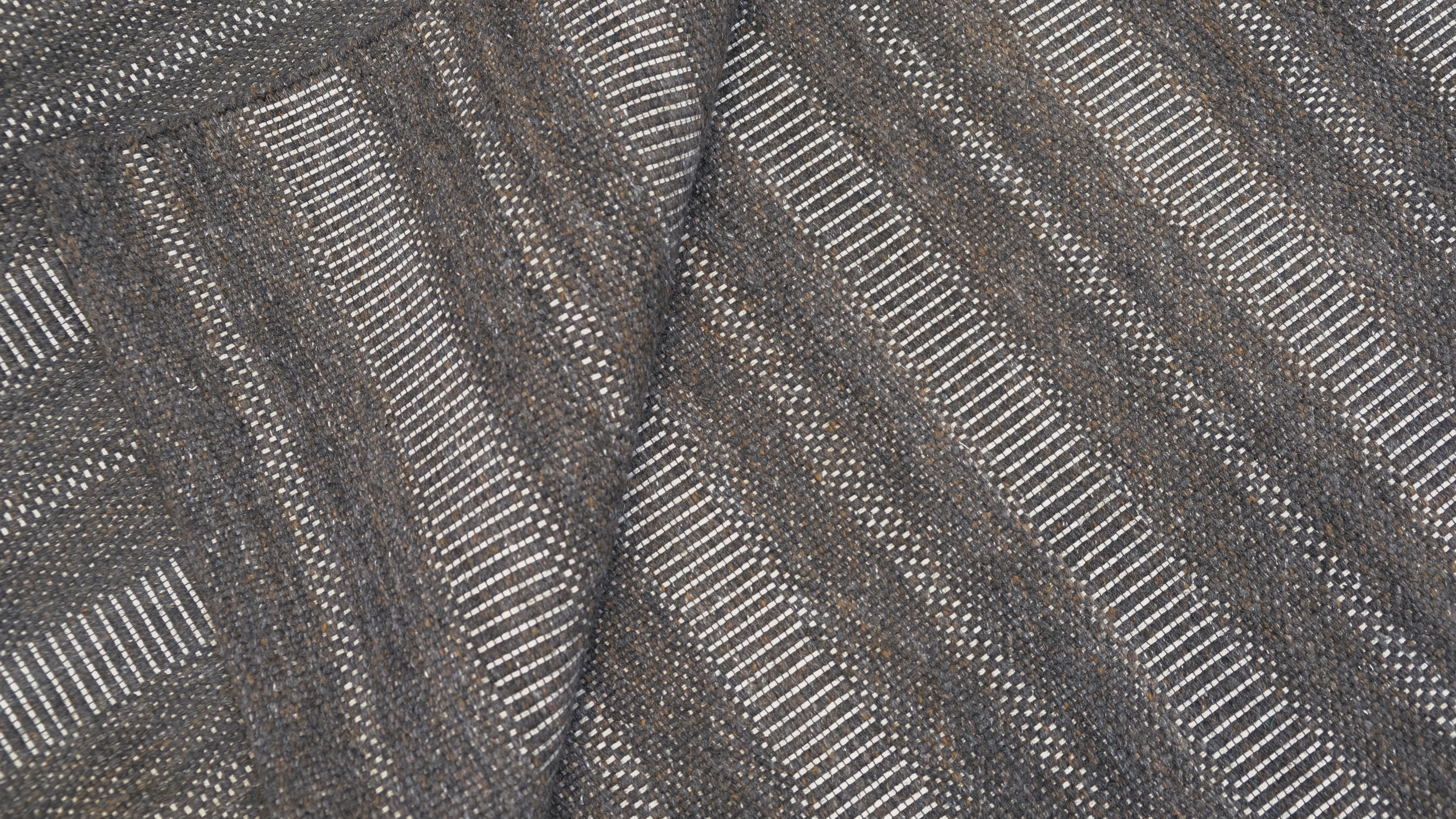 Elevate your interior with this expertly hand-woven wool rug, featuring a refined striped texture in a versatile neutral brown grey  palette. This contemporary design offers subtle sophistication and texture, making it an ideal choice for modern,