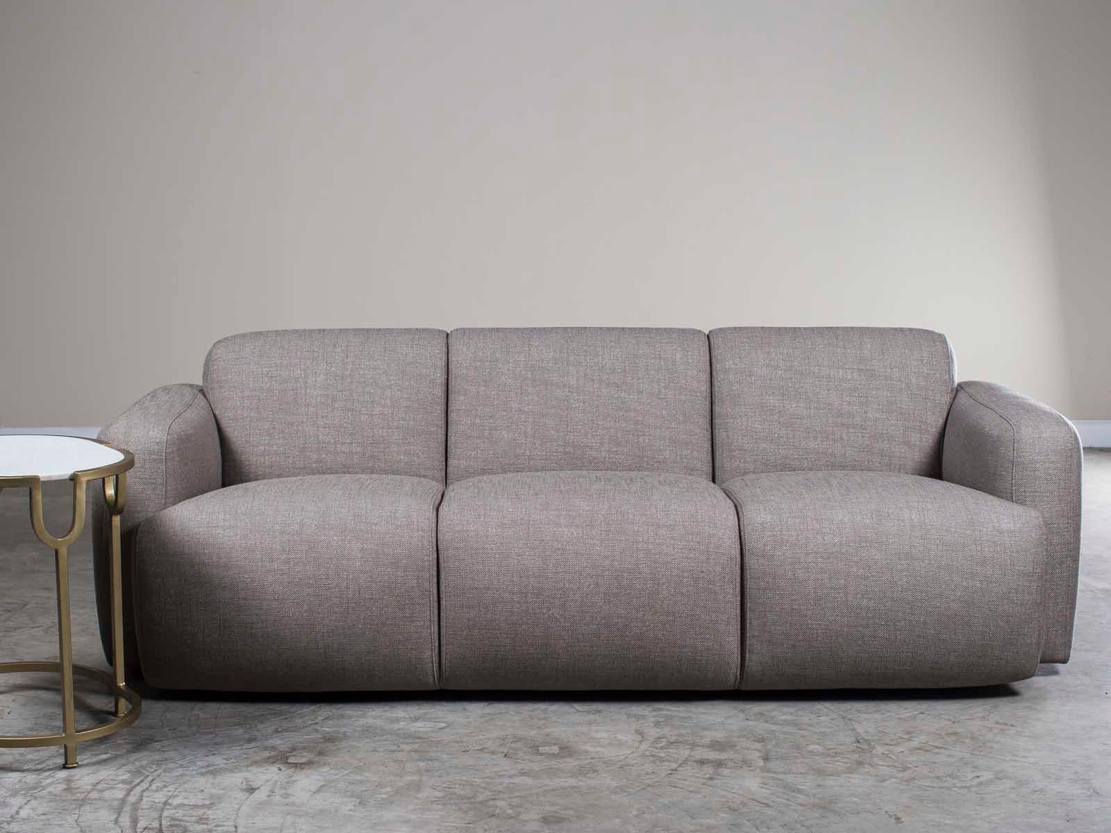 An inviting modern grey linen three cushion sofa from Holland having contemporary rounded lines with a finished back. The soft color of the upholstery combined with the gentle curves immediately signals 