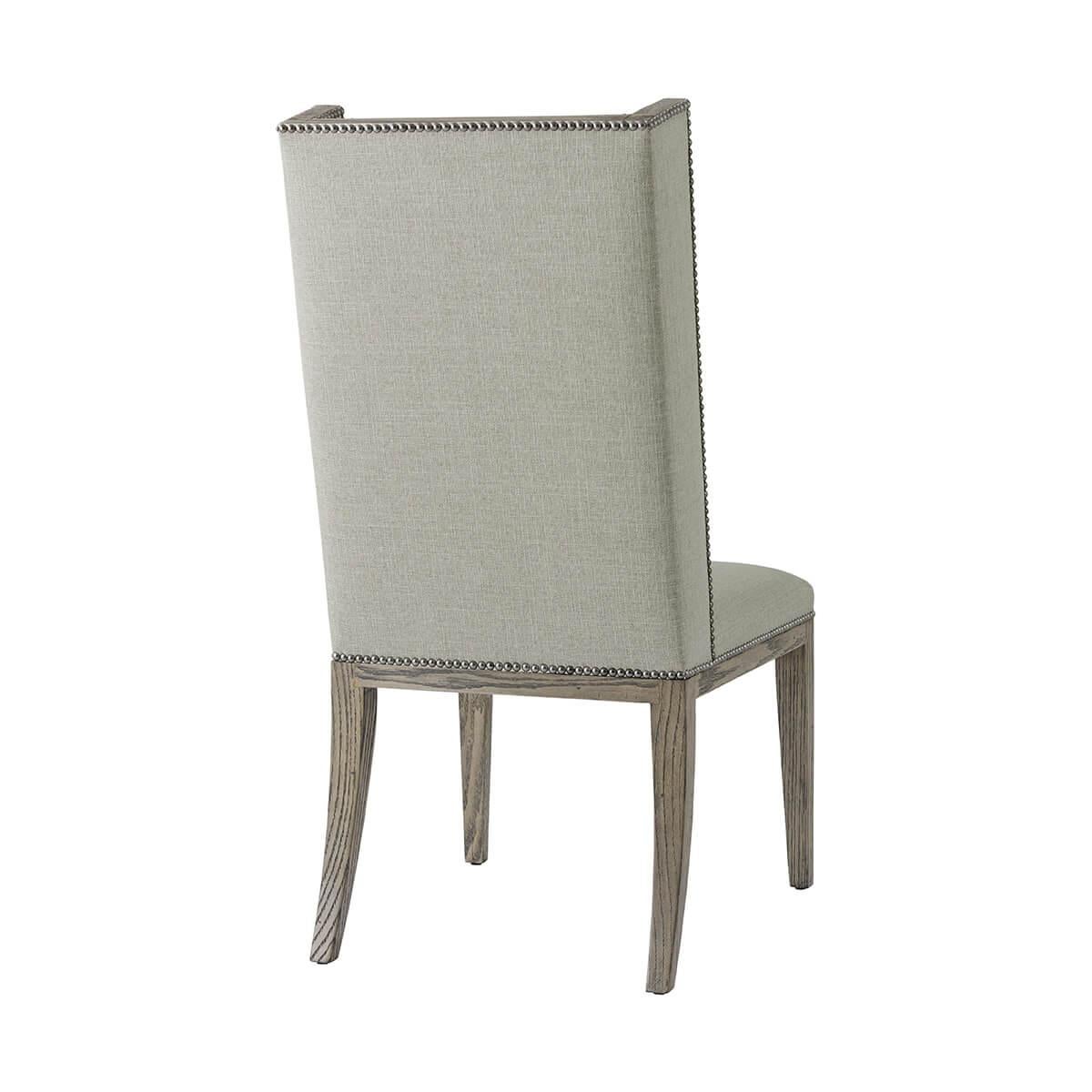 Upholstered Dining Chair in a grey echo oak finish frame. The slender winged back and seat are upholstered in performance fabric. Raised on square tapered legs.

Dimensions: 21.5