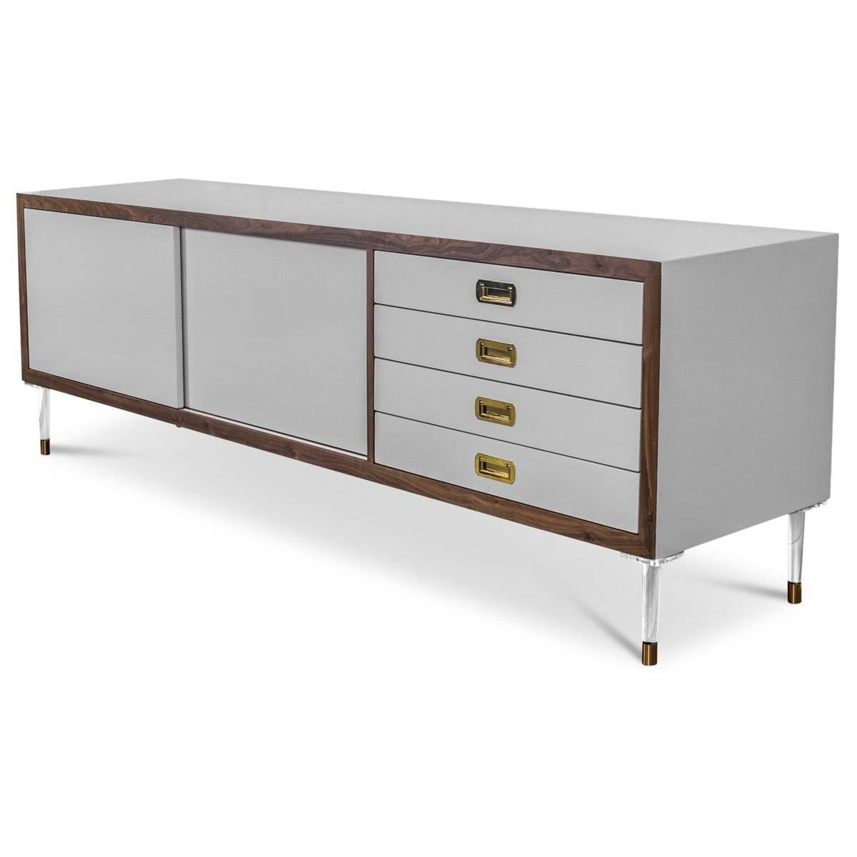 Introducing our new St. Martin Credenza featuring two sliding doors and four drawers to maximize its functionality while still being stylish and chic. This retro-modern design features an oiled walnut trim, brass hardware, our famous Greystone