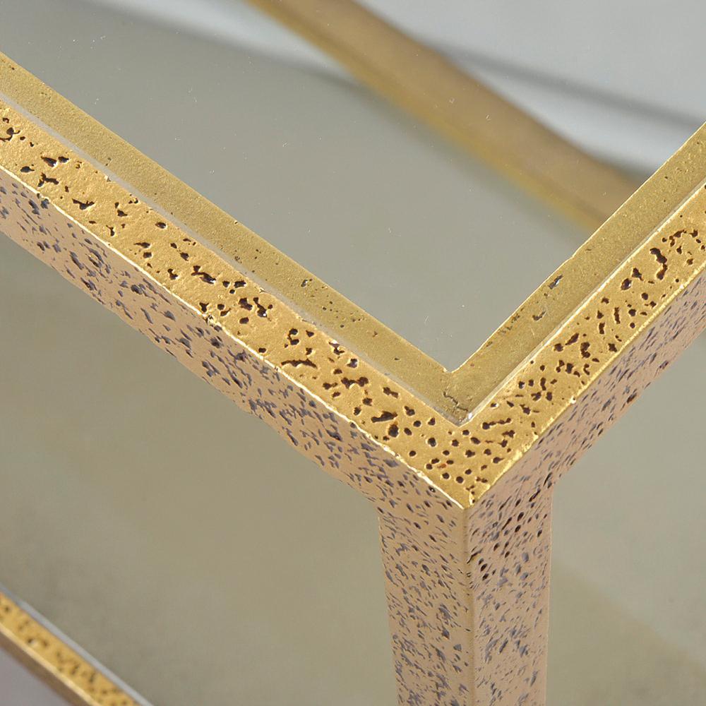 A modern hammered rectangle coffee table, with a clear tempered glass top, has a “gold leaf” finish on cast textured aluminum frame and tapered legs.

Dimensions: 40