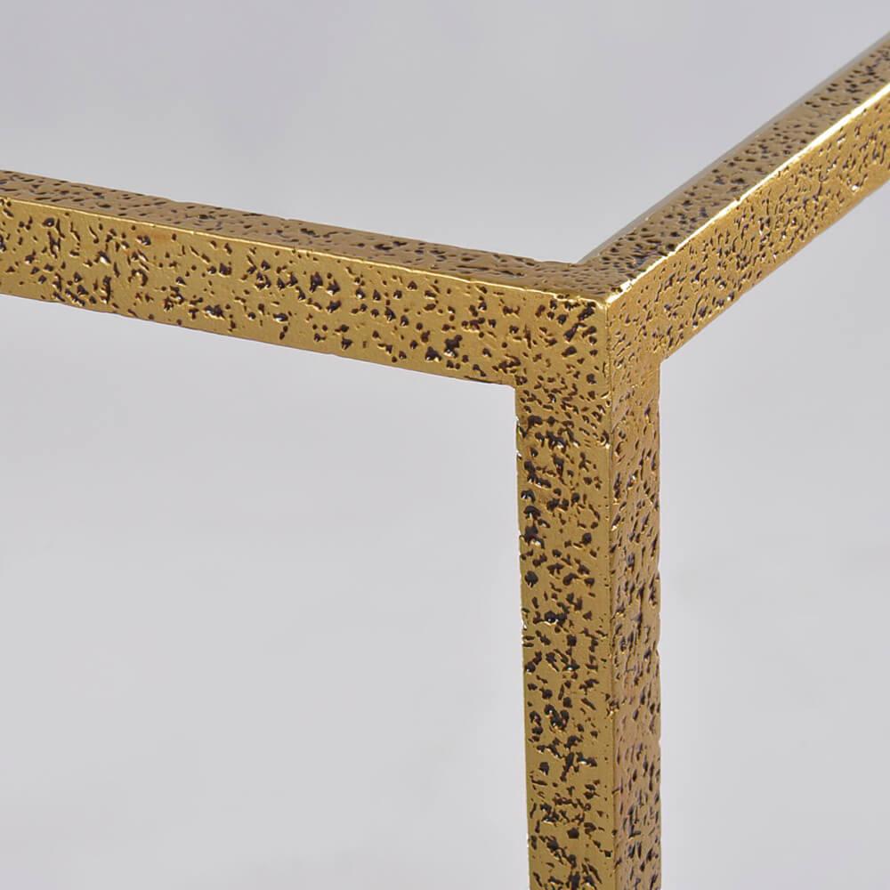 A modern hammered narrow rectangle side table, with clear tempered glass top and shelf, has a “gold leaf” finish on cast textured aluminum frame and tapered legs.

Dimensions: 24