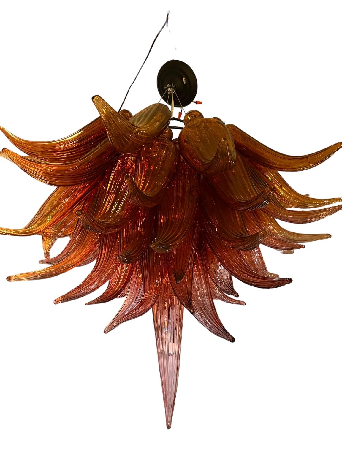 Beautiful hand blown studio glass chandelier in the style of American artist Dale Chihuly. Unique tulip shape with a beautiful pinkish orange hue. Circa 1980’s Dimensions 30-32 inches wide, 32-36 inches high.
Dale Chihuly has established himself as