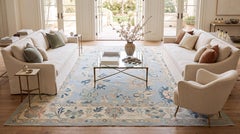 Alfombra moderna de lana, anudada a mano al estilo Oushak, con motivos florales en azul claro y tonos tierra suaves