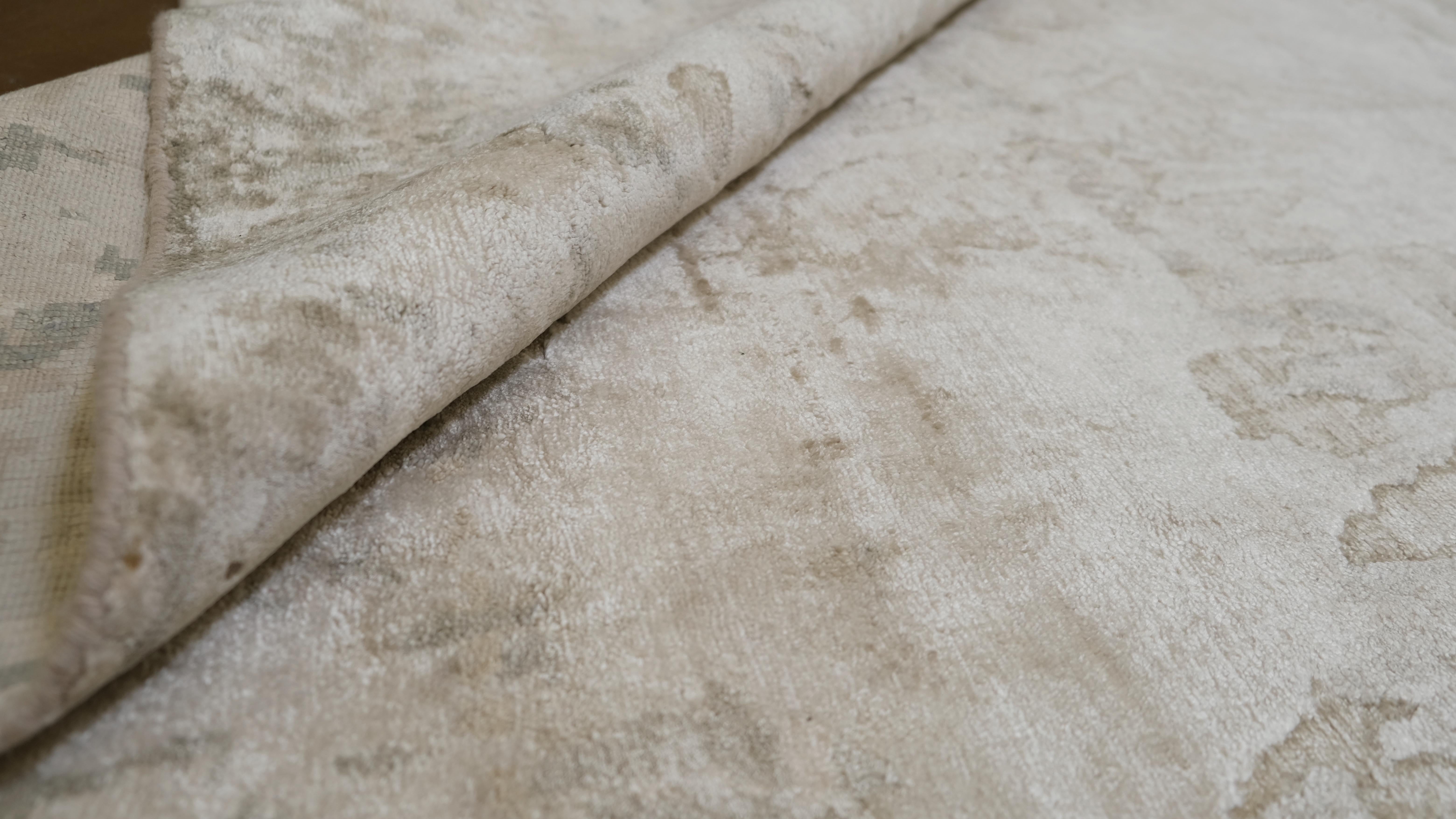 Transform your space with the refined beauty of this hand-knotted bamboo silk rug. Featuring an abstract design in neutral shades of beige and grey, this rug offers a sophisticated and serene foundation for contemporary and transitional interiors.