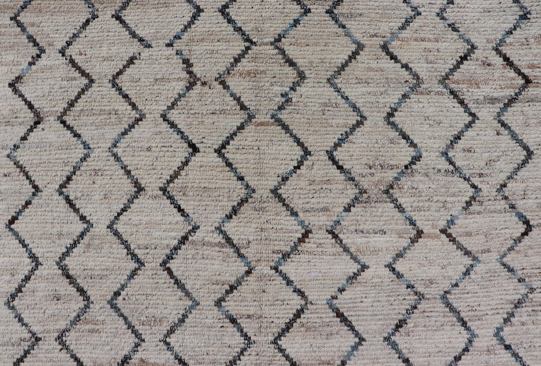 This modern casual tribal rug has been hand-knotted. The rug features a modern all-over geometric zig-zag design, rendered in blue, charcoal, brown and cream; making this rug a superb fit for a variety of classic, modern, casual and minimalist