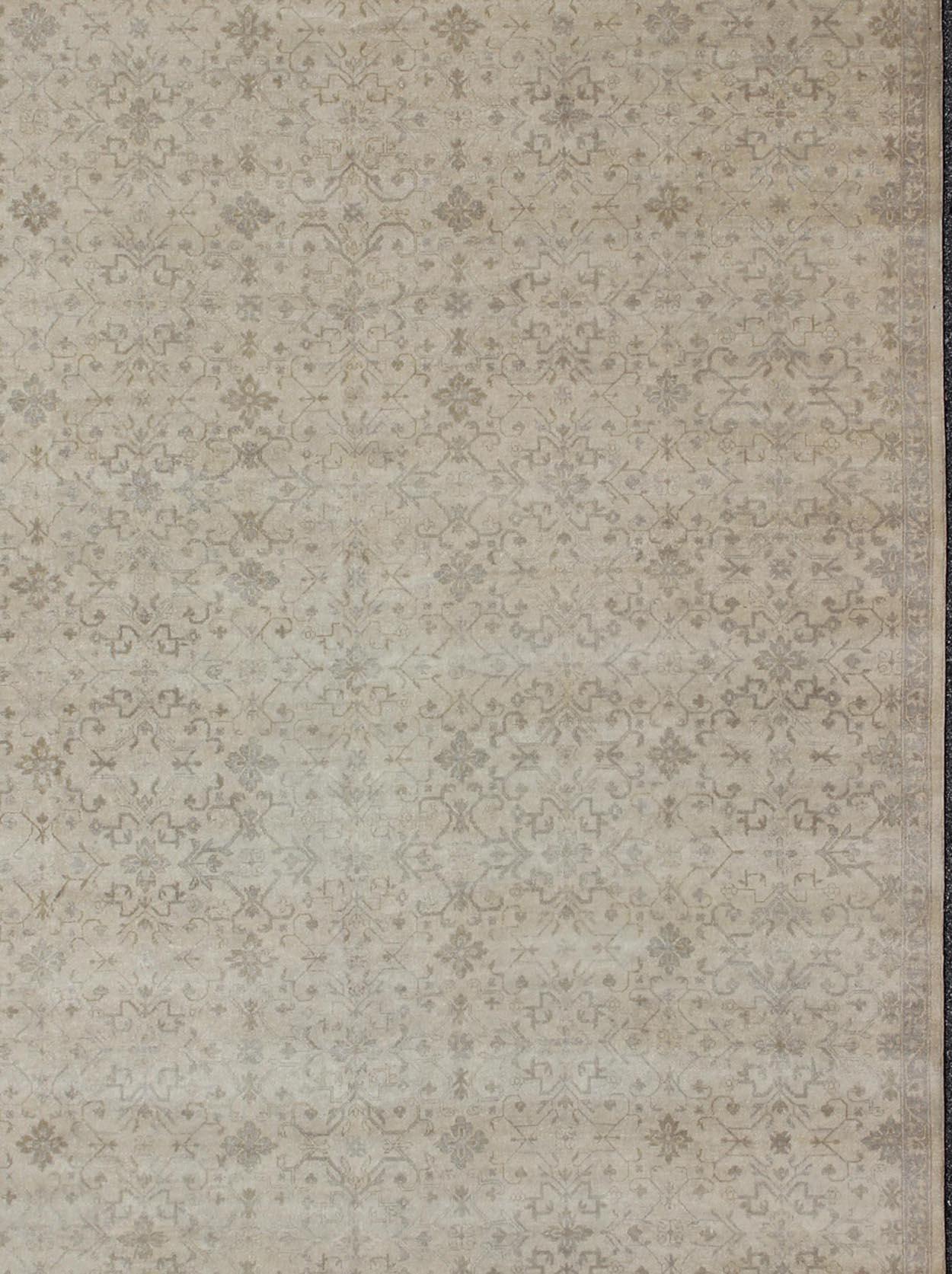 This modern hand-knotted Khotan features a geometric, all-over design flanked by a repeating pattern in the border. The entirety of the piece is rendered in light tones, which makes it a versatile rug, well-suited for a wide variety of