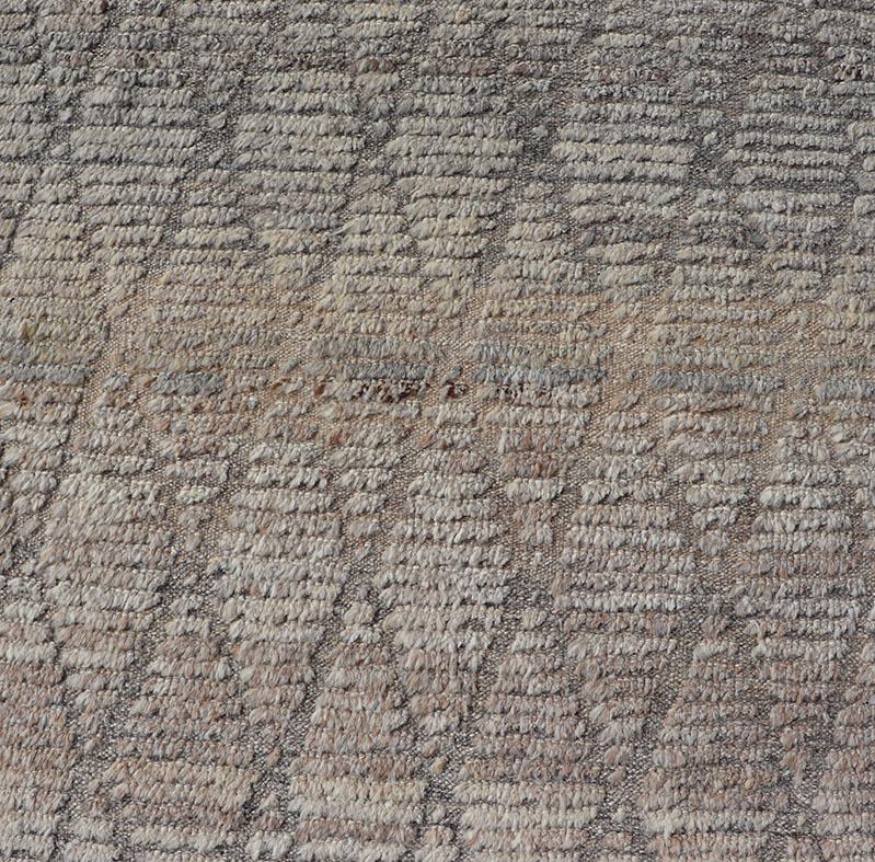 Dieser moderne, lässige Tribal-Teppich wurde aus Wolle handgeknüpft. Der Teppich zeichnet sich durch ein modernes geometrisches Rautenmuster aus, das in grauen und neutralen Tönen gehalten ist. Damit passt er hervorragend zu einer Vielzahl