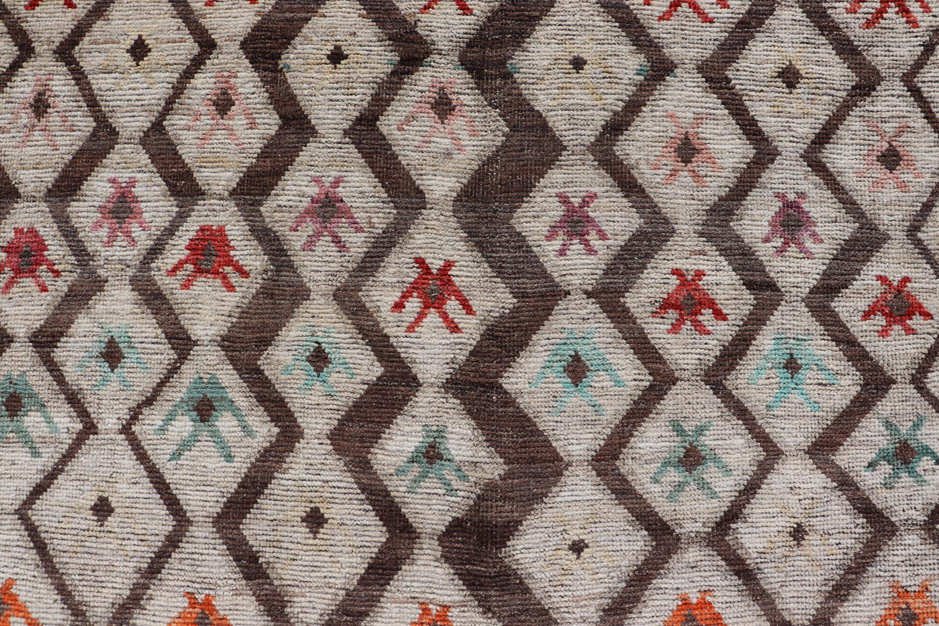 This modern casual tribal rug has been hand-knotted. The rug features a modern all-over sub-geometric diamond design, replete with various motifs in multicolor, making this rug a superb fit for a variety of classic, modern, casual and minimalist