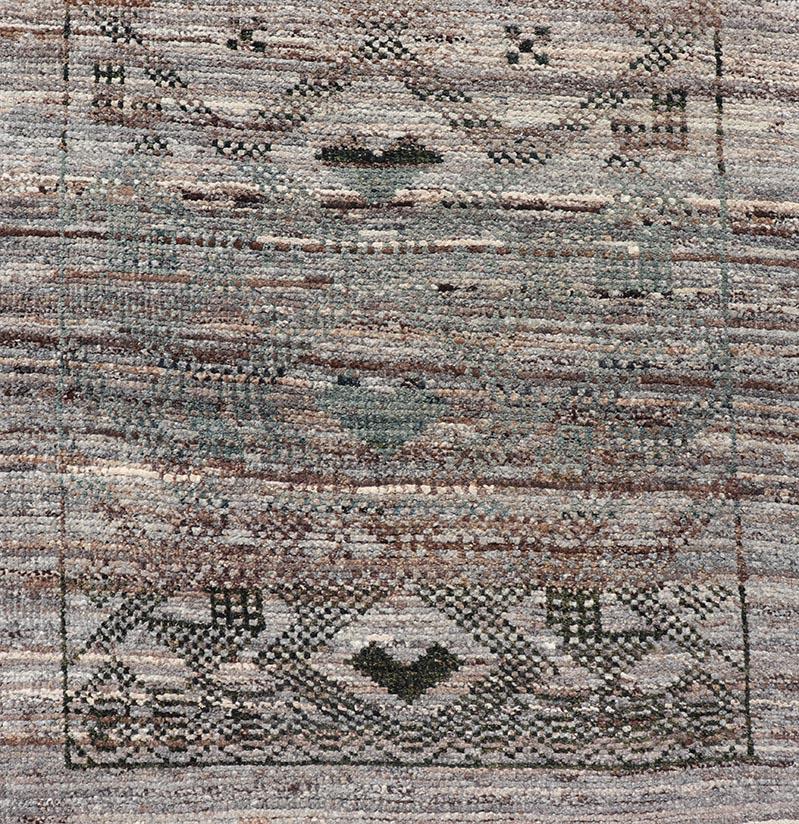 This modern casual tribal runner has been hand-knotted in wool. The runner features a modern all-over sub-geometric diamond design, replete with various motifs in charcoal, brown, and neutral tones; making this rug a superb fit for a variety of