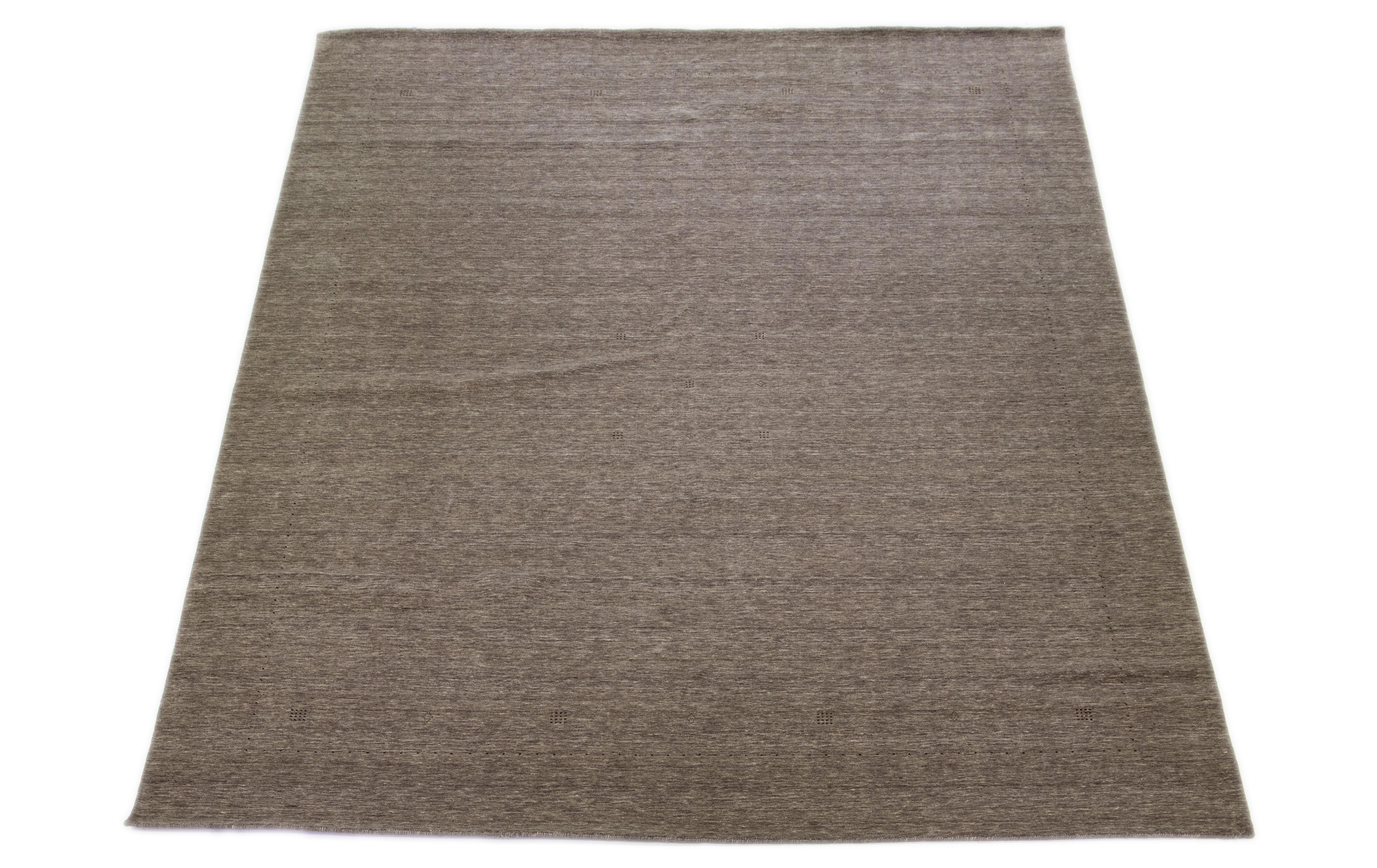 This modern Gabbeh rug, hand-loomed with exceptional care, embodies elegance and contemporary style with its minimalist geometric pattern. The alluring brown base is finely accented with dark brown details.

This rug measures 12'1