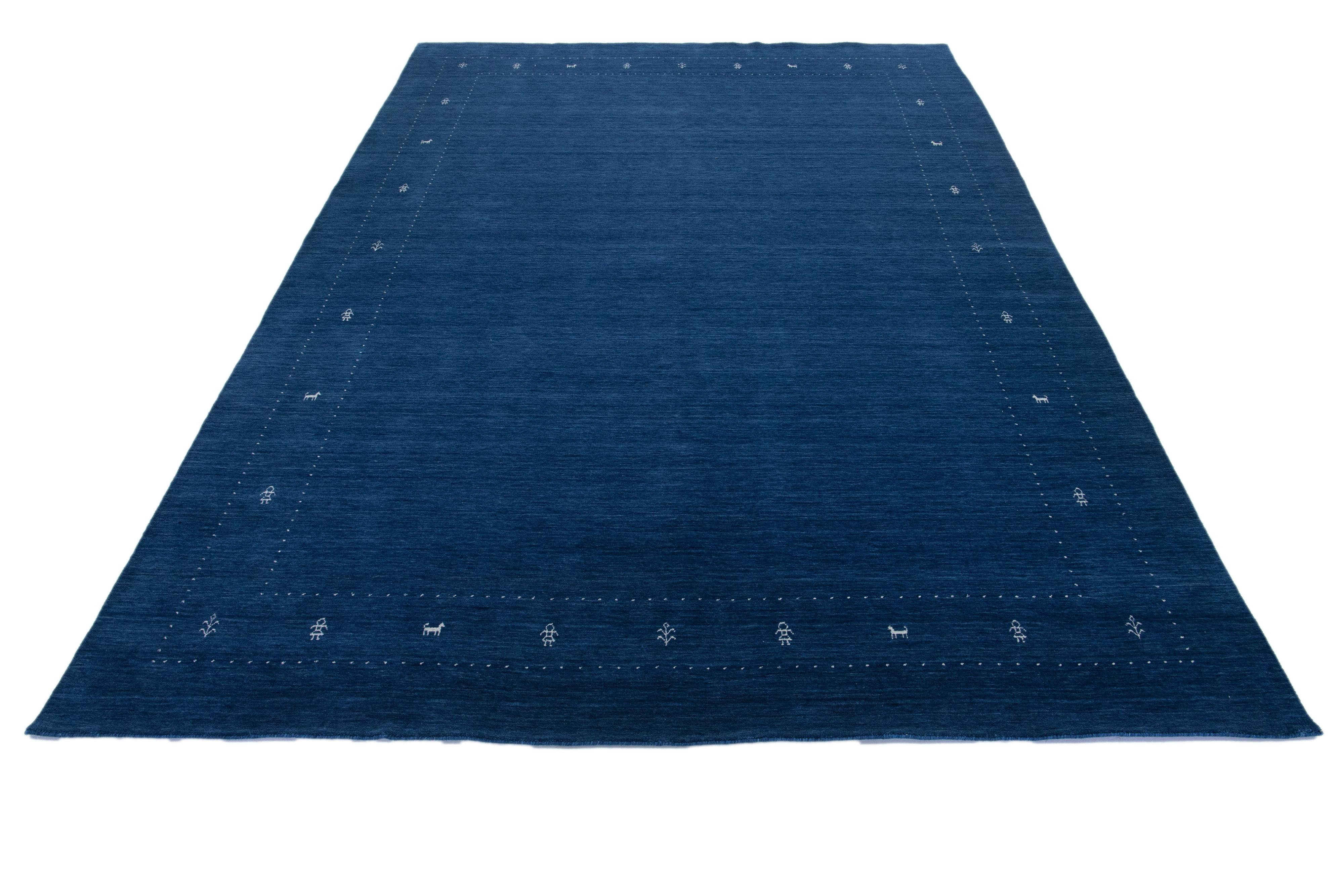 This modern Gabbeh rug is hand-loomed with a contemporary minimalist geometric pattern. The blue base is accented with white details.

This rug measures 10' x 13'9