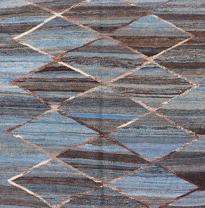 This flat-weave Kilim has been hand-woven. The rug features a modern diamond design, rendered in brown, blue, and gray. making this rug a superb fit for a variety of Classic, modern, casual and Minimalist interiors.

Modern Kilim Rug, Keivan Woven