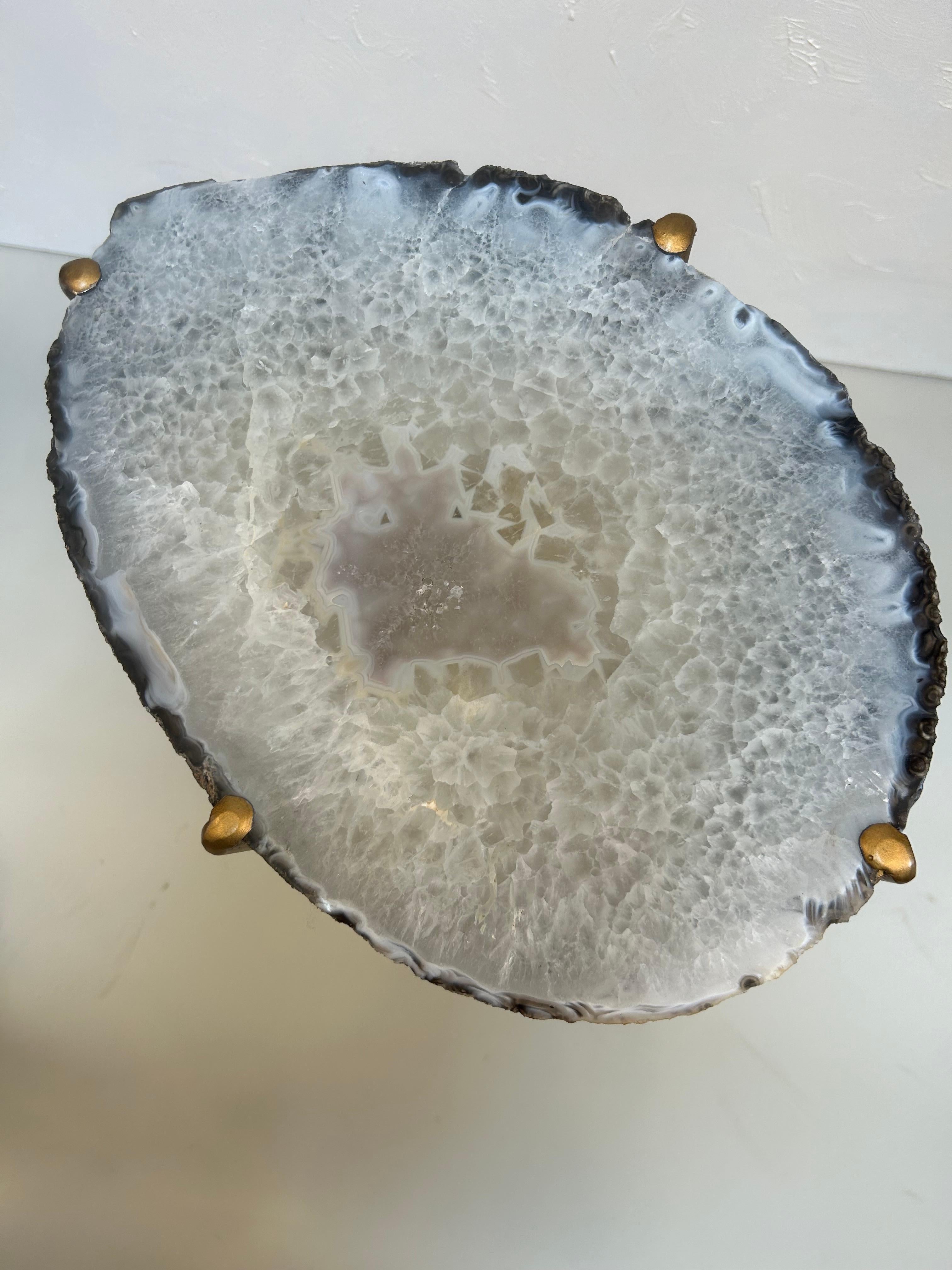 A beautiful handcrafted drinks table by Hastening Designs, made in the United States in the 2020s. This refined accent piece features a one-of-a-kind quartzite geode slab, celebrated for its dramatic crystalline core and rich concentric banding in