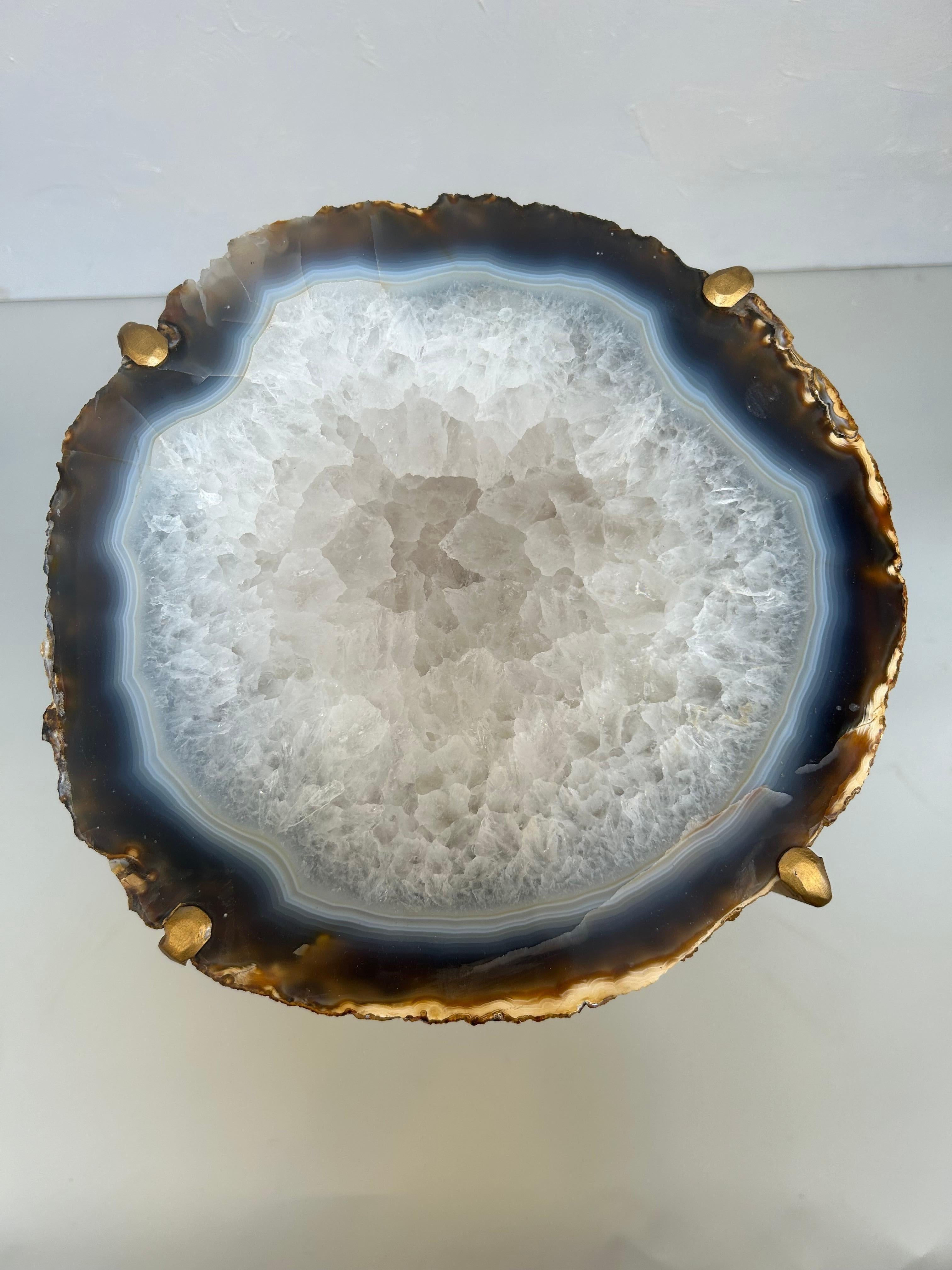 Nos magnifiques tables à boissons en géodes sont un complément parfait à tout salon, en particulier dans une zone où le soleil les frappe juste comme il faut. Fabriqué à la main avec des plaques de quartzite uniques et du métal doré. Cette grande