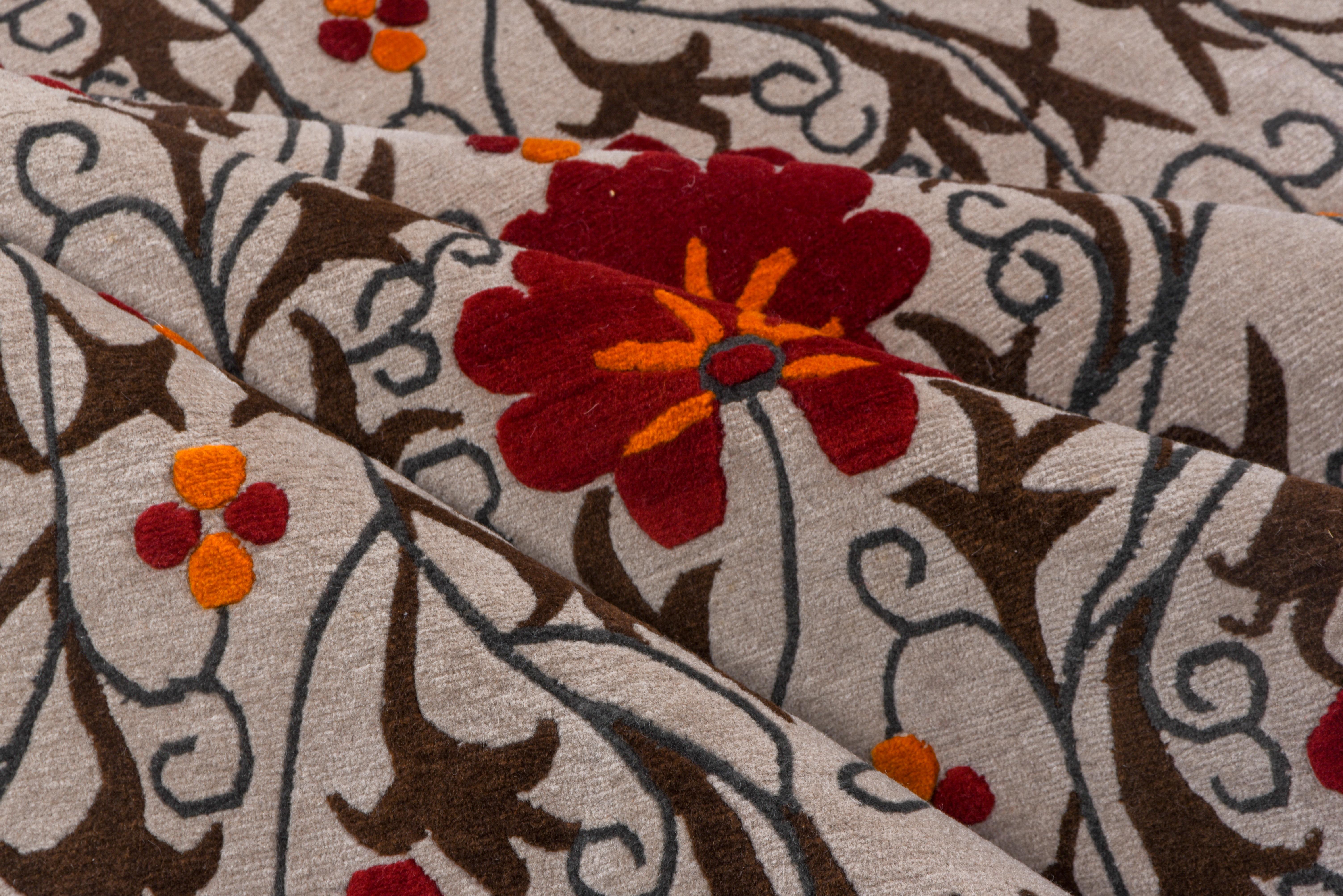 Der cremefarbene, randlose Grund zeigt einen sich vertikal wiederholenden Rapport aus roten Blüten und schlanken, mit Stacheln besetzten Blättern in einem Stil, der an usbekische Suzani-Stickereien erinnert. Sieht aus wie ein riesiges Textil mit