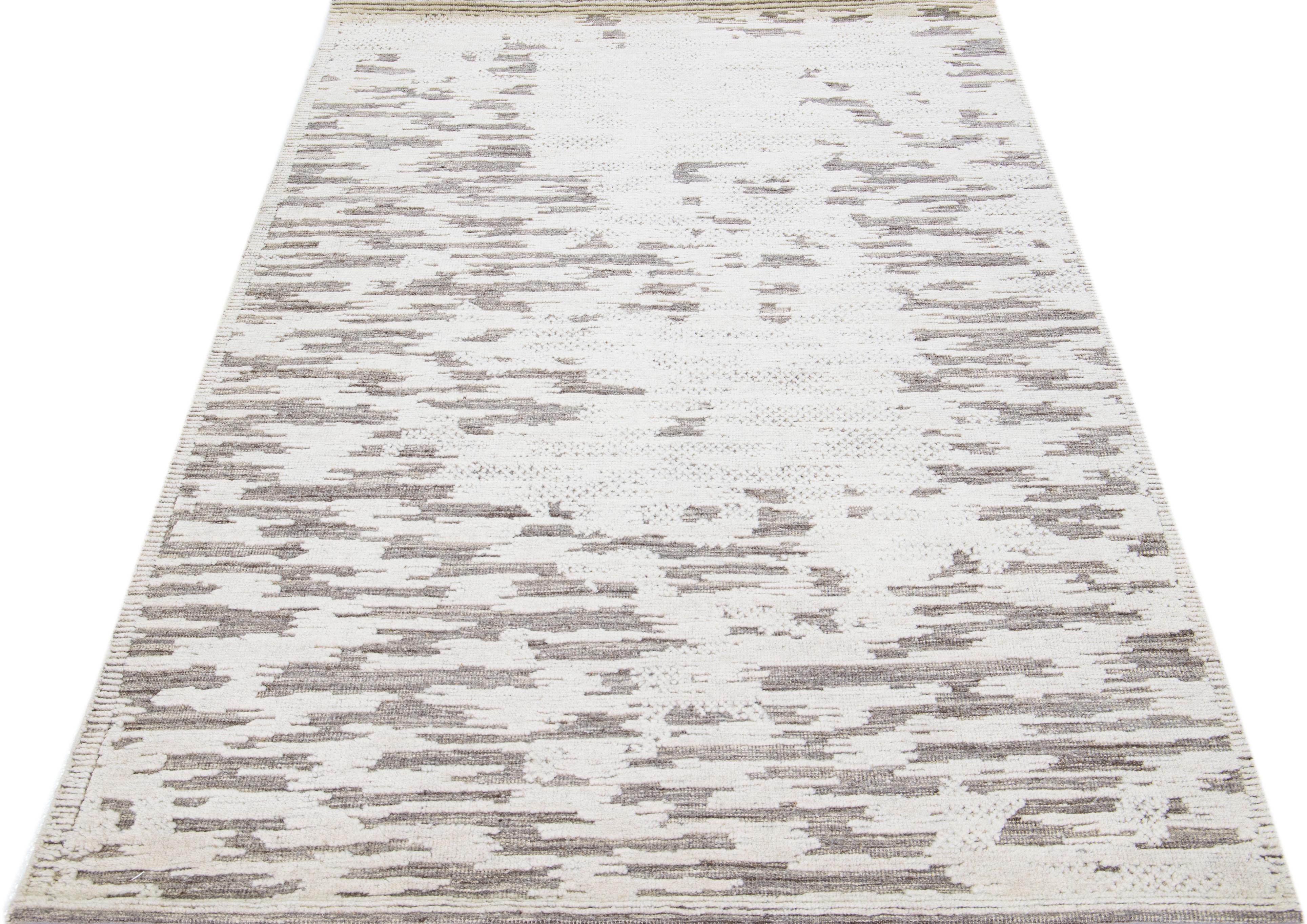 Beautiful modern Moroccan-style hand-knotted wool rug with a beige and ivory color field. This rug is part of our Apadana's Safi Collection and features an abstract design in gray.

This rug measures: 5'2