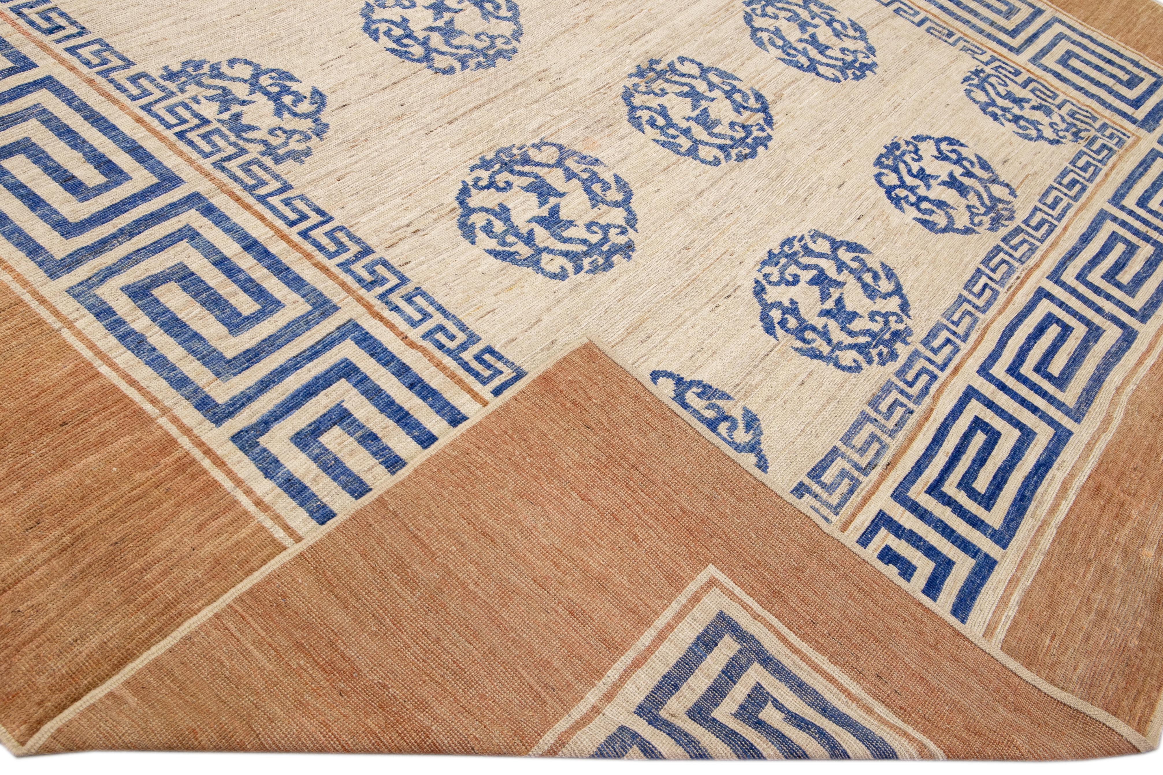 Beautiful handmade wool rug with a beige field. This Modern rug has a tan frame and blue accents featuring a gorgeous all-over greek key pattern design.

This rug measures: 11'11