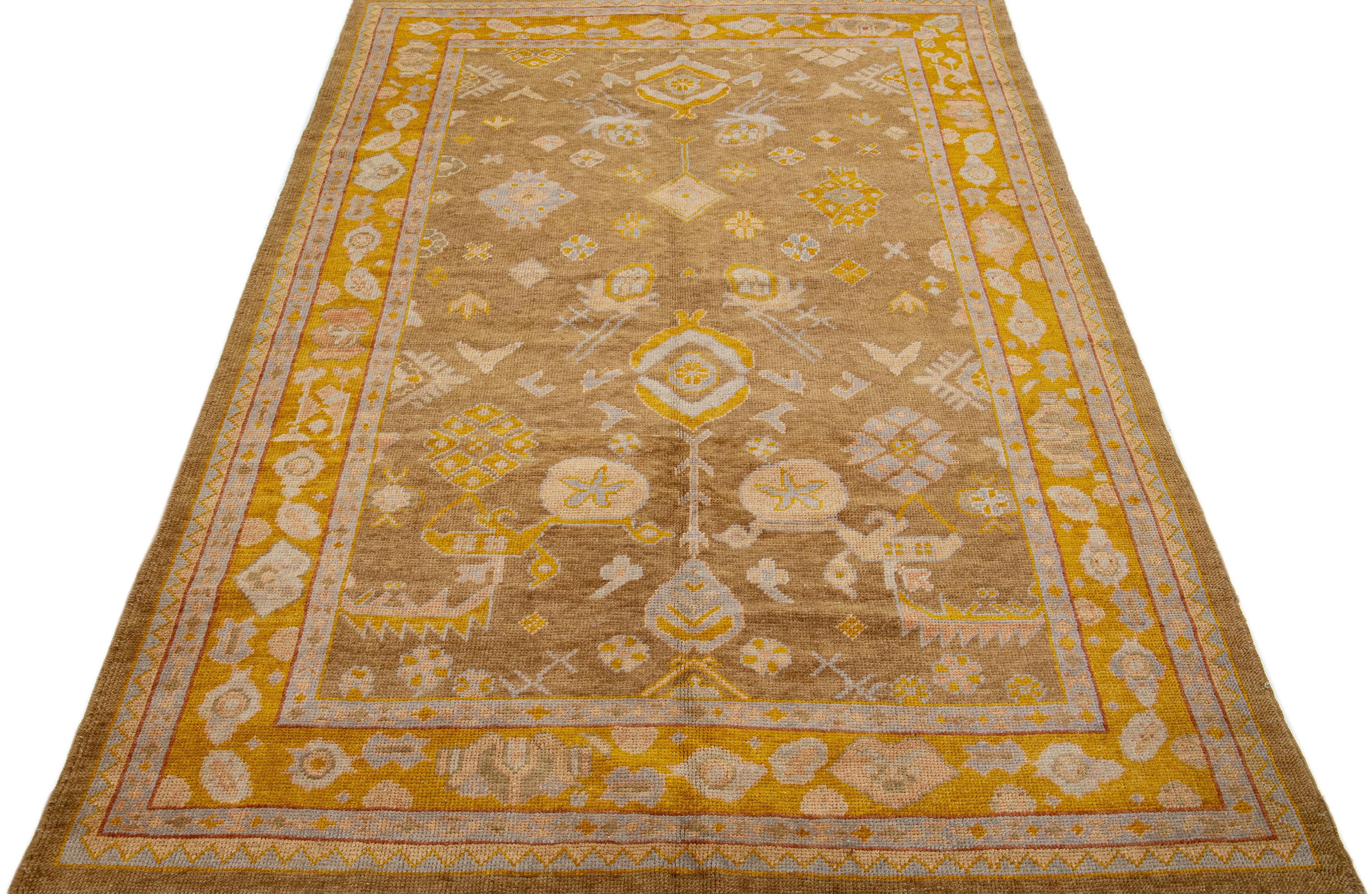 Beautiful Modern Turkish hand-knotted wool rug with a brown color field. This rug has a goldenrod-designed frame with accent colors of peach and gray in a gorgeous all-over geometric floral design.

This rug measures: 6'1