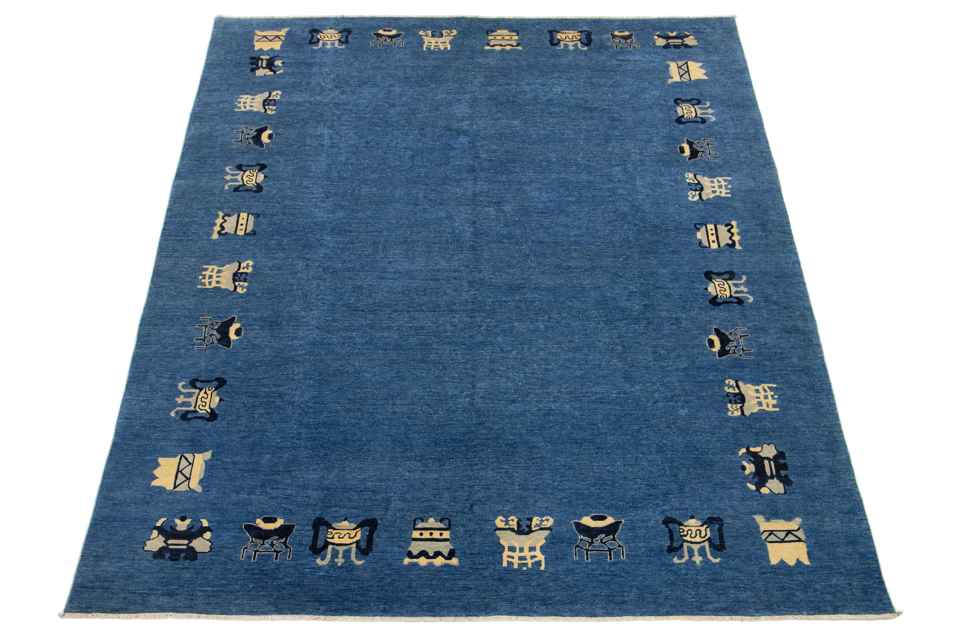 Superbe tapis moderne en laine nouée à la main, de style chinois, avec un fond bleu marine et des accents beiges dans le dessin traditionnel chinois.

Ce tapis mesure 9'6