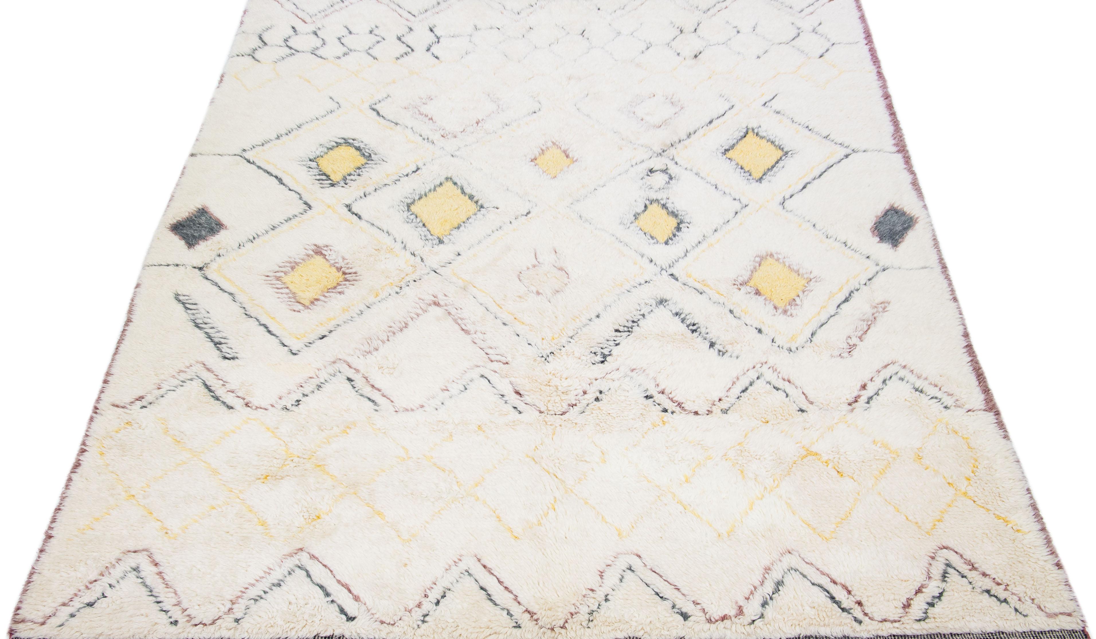 Beautiful Moroccan-style handmade wool rug with an Ivory color field. This Modern rug has gray, yellow, and brown accents featuring a gorgeous all-over geometric tribal design.

This rug measures: 9'3