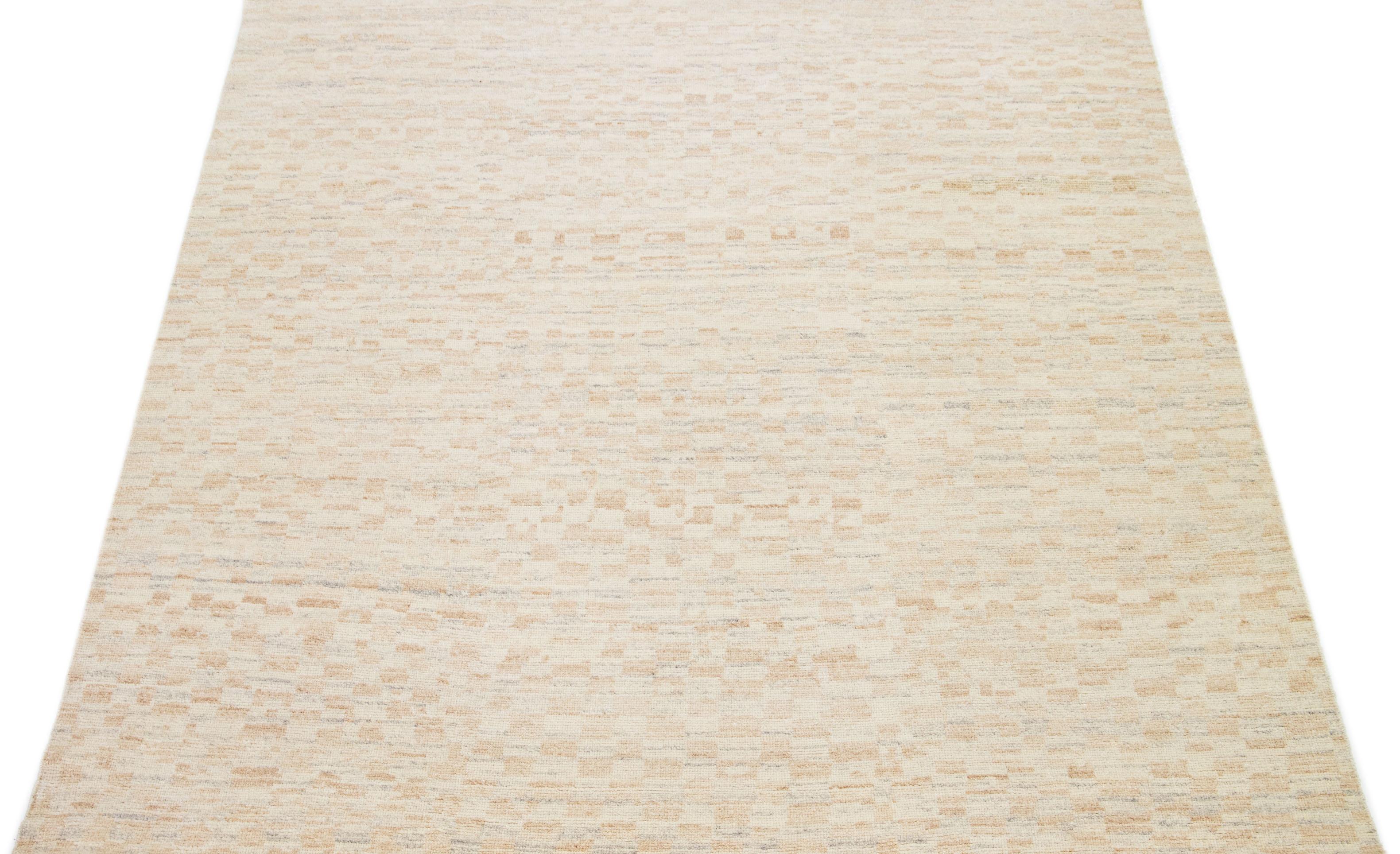Dieser handgeknüpfte Wollteppich zeigt ein marokkanisches Muster, vorwiegend in Braun- und Grautönen, ergänzt durch einen bezaubernden beigen Hintergrund. Die atemberaubende geometrisch-abstrakte Ausstellung verleiht jedem Raum einen