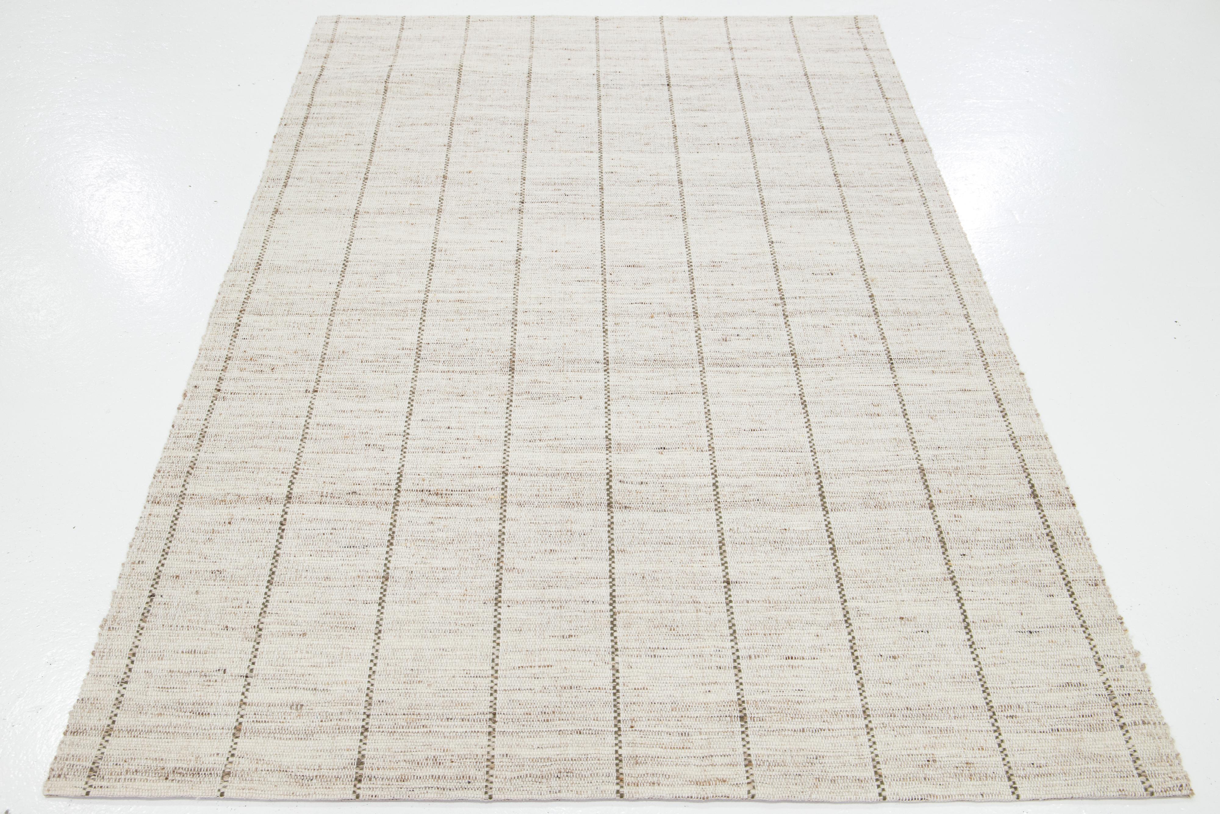 Dieser schöne handgewebte Wollteppich aus Filz ist Teil unserer Westport Collection'S. Es hat ein beigefarbenes Feld mit grünen und braunen Akzenten und durchgehendem geometrischem Muster.

Dieser Teppich misst 5' x 8'.

Kundenspezifische Farben und