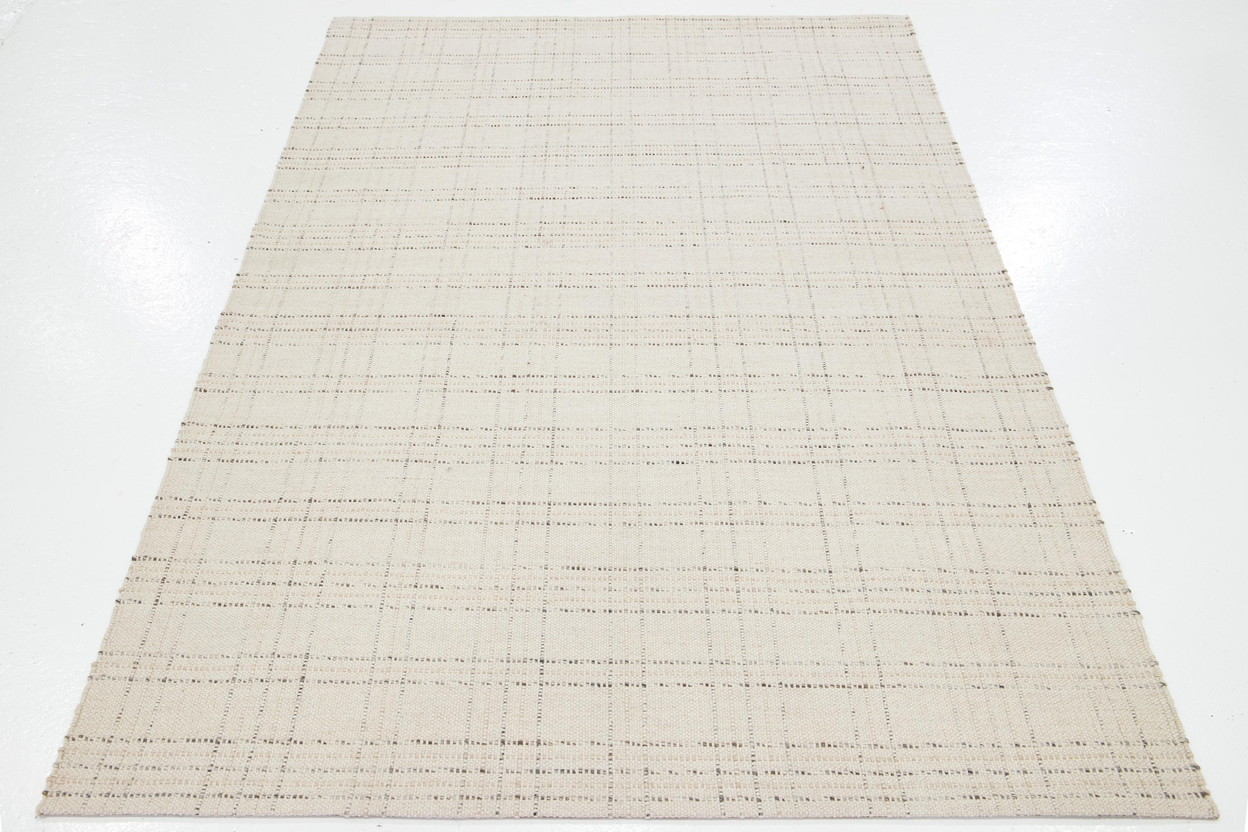 Dieser schöne, handgewebte Wollteppich aus Filz ist Teil unserer Collection'S Sasco. Es hat ein beiges Feld mit grauen Akzenten und durchgehendem geometrischem Muster.

Dieser Teppich misst 5' x 8'.

Kundenspezifische Farben und Größen sind auf