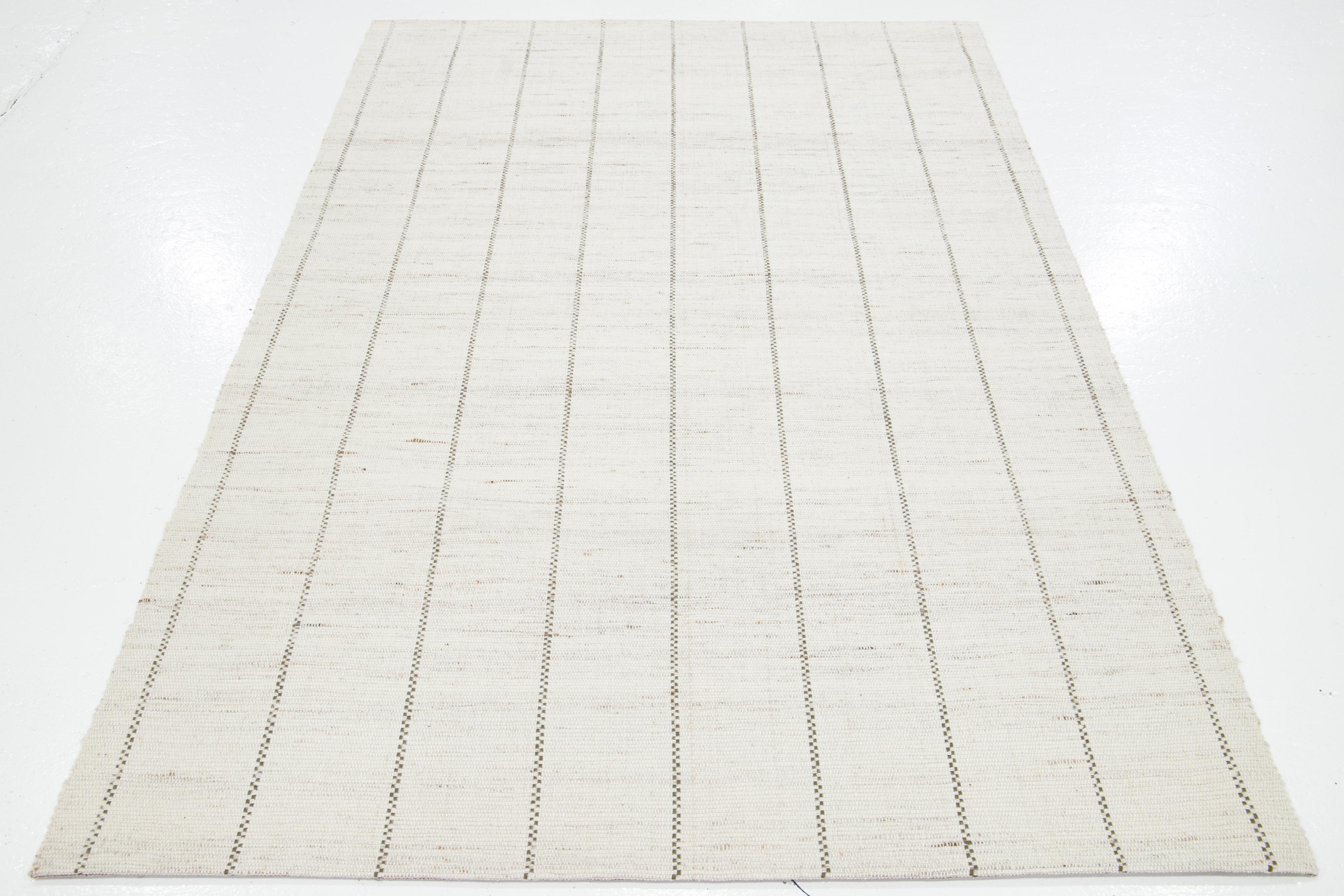 Dieser schöne handgewebte Wollteppich aus Filz ist Teil unserer Westport Collection'S. Es hat ein elfenbeinfarbenes Feld mit grünen und braunen Akzenten und durchgehendem geometrischem Muster.

Dieser Teppich misst 5' x 8'.

Kundenspezifische Farben