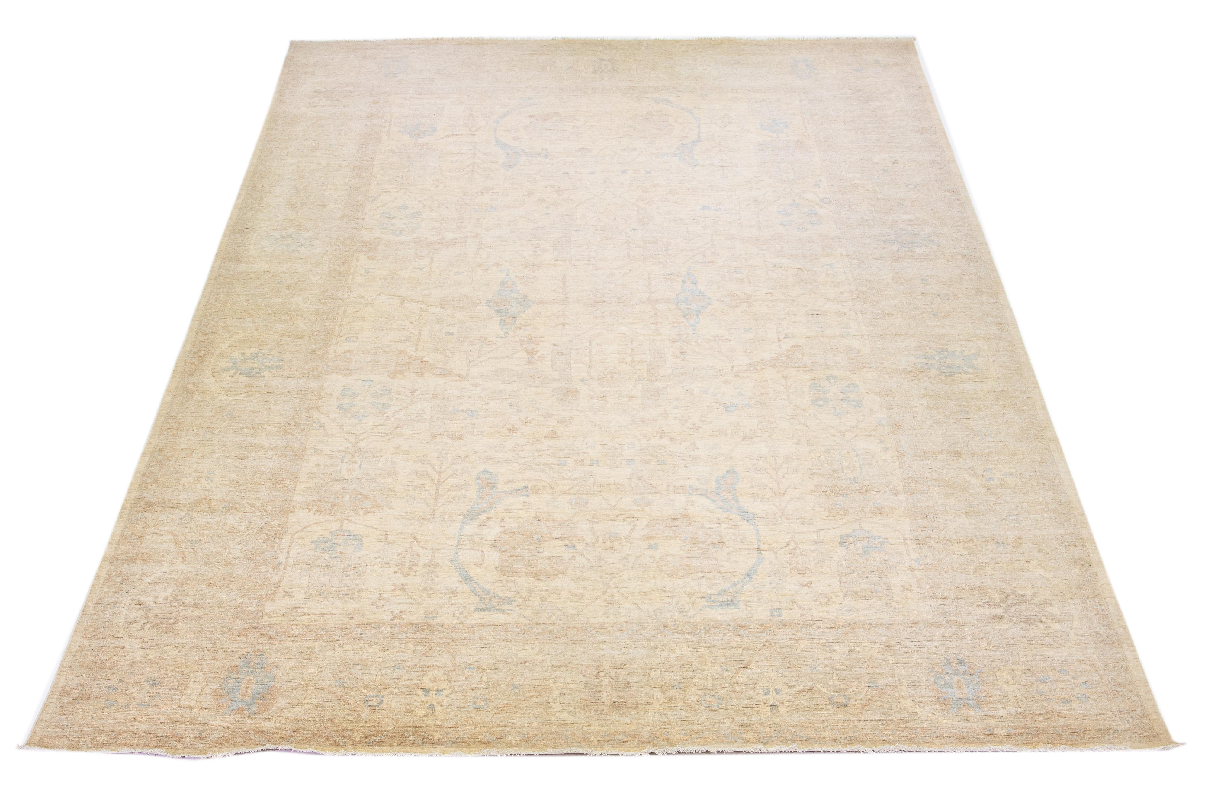 Beautiful modern Oushak hand-knotted wool rug with a beige color field. This Piece has brown and blue accent colors in a gorgeous all-over floral motif.

This rug measures: 12'5