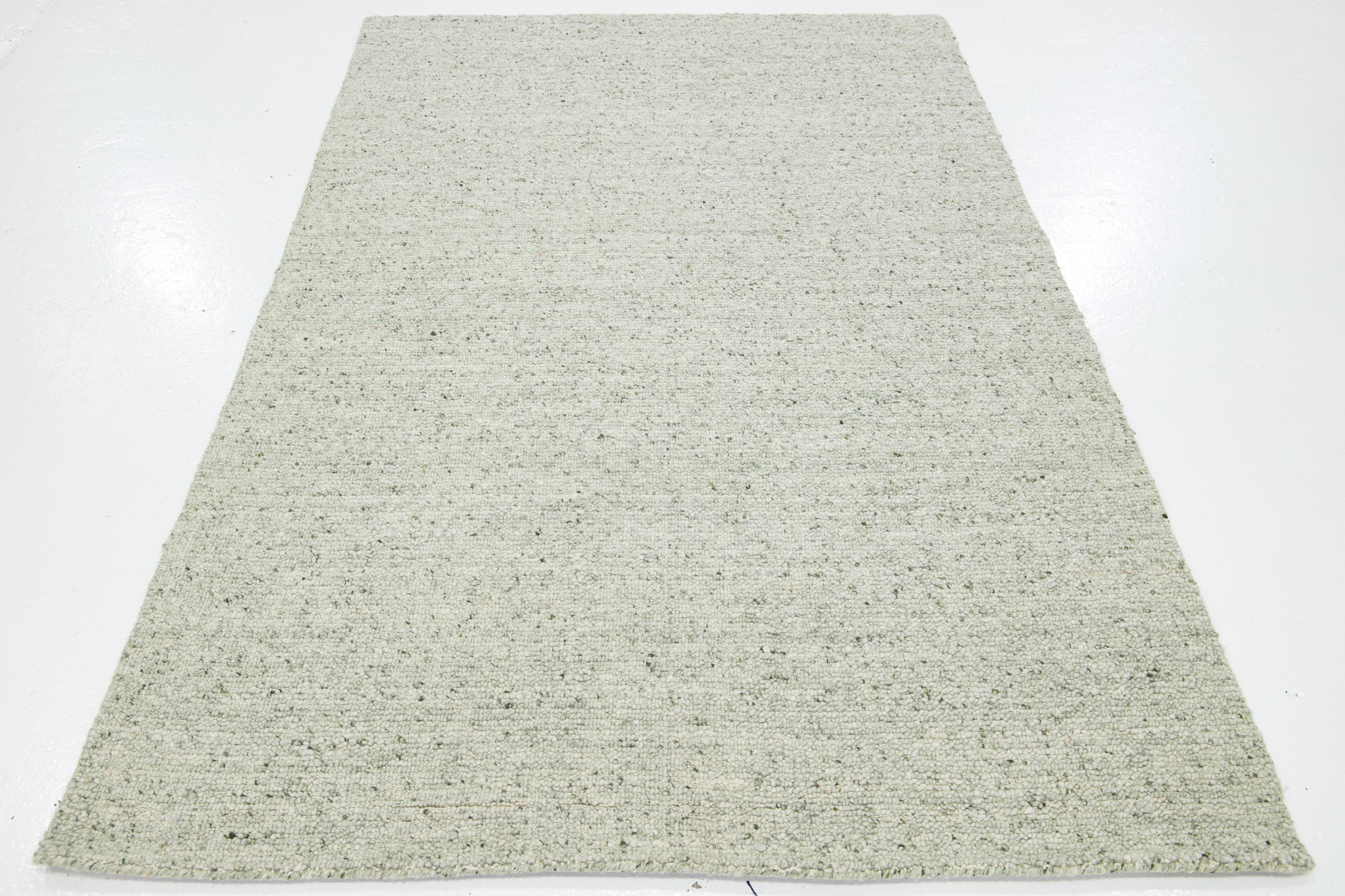 Esta preciosa alfombra de lana anudada a mano de textura moderna, que forma parte de nuestra colección Sasco, presenta un campo verde claro y un asombroso diseño texturizado que se asemeja a guijarros.

Esta alfombra mide 5' x 8'.

Nuestras