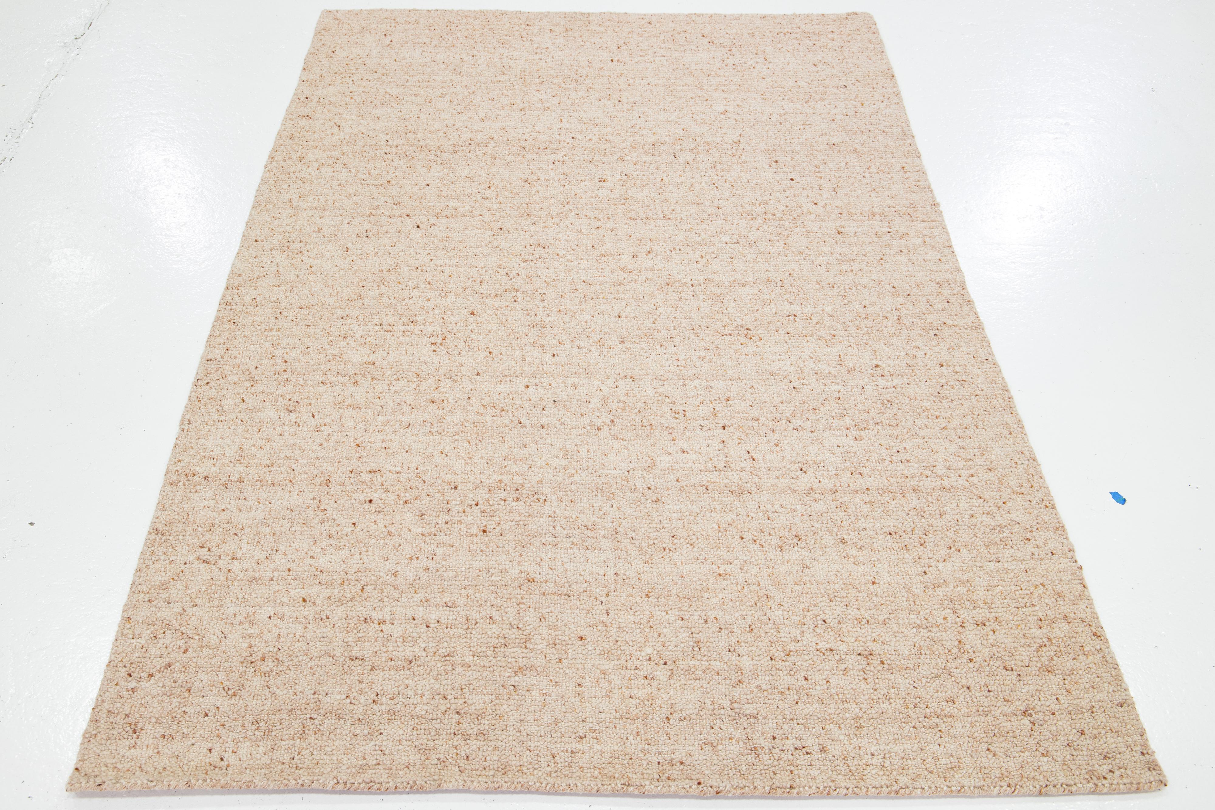Dieser wunderschöne, modern strukturierte, handgeknüpfte Wollteppich aus unserer Collection'S Sasco zeichnet sich durch ein hellrosa Feld und ein atemberaubendes, strukturiertes Muster aus, das an Kieselsteine erinnert.

Dieser Teppich misst 5' x