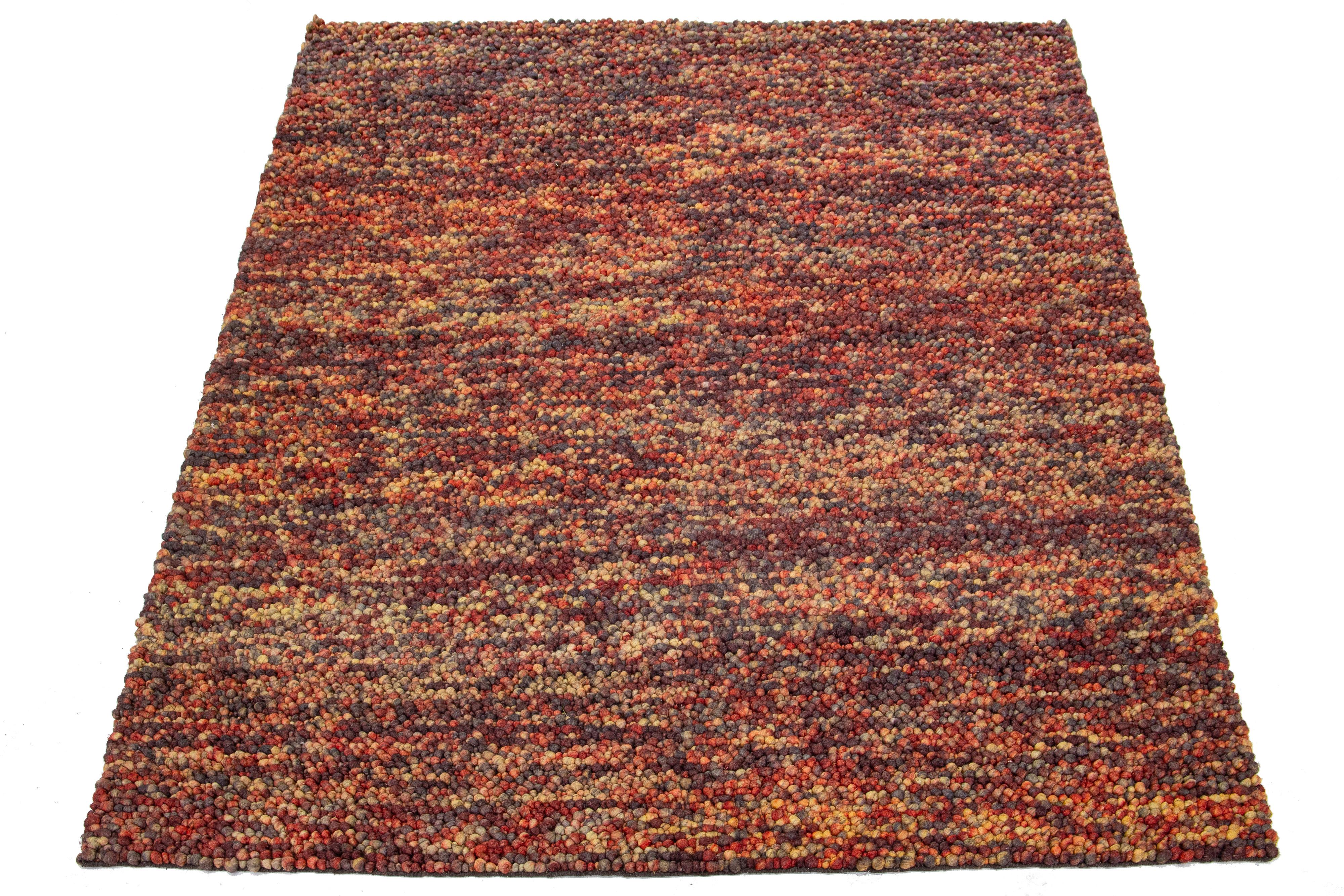 This beautiful, modern texture hand-knotted wool rug part of our Saco collection features a color field of yellow, orange, gray, and red. The rug also boasts a stunning textured abstract design resembling pebbles.

This rug measures 8' x 11'.

Our