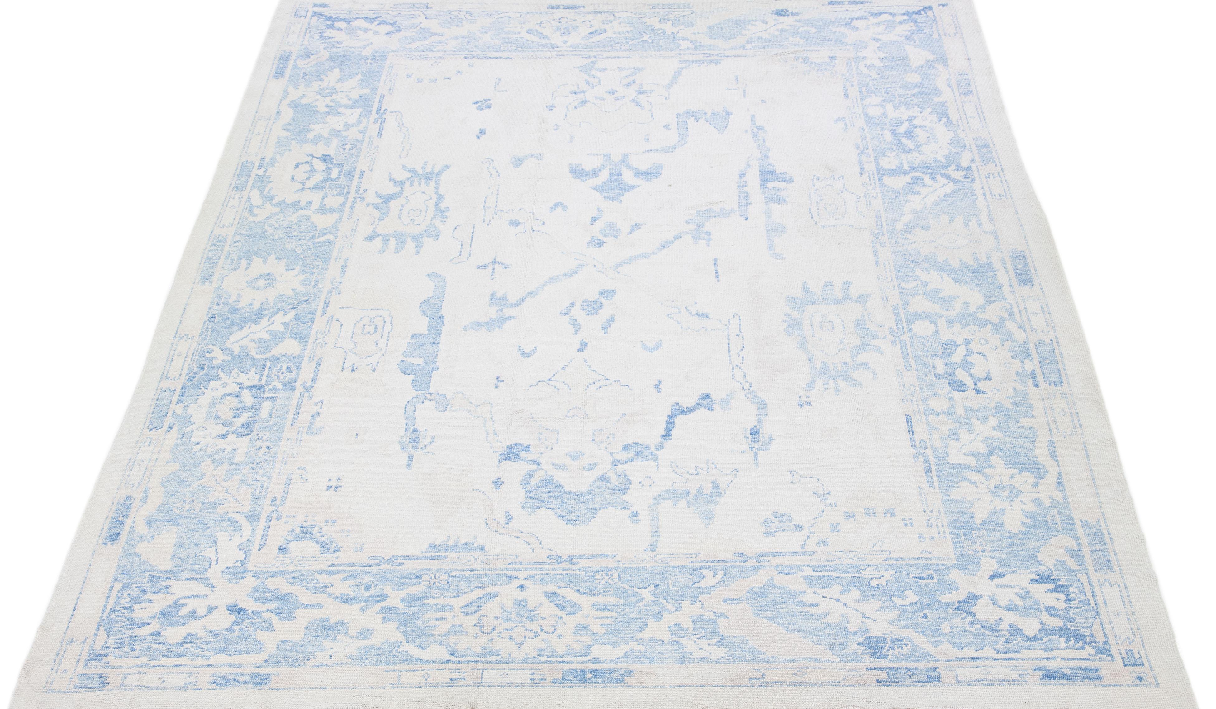 Beautiful modern Oushak hand-knotted wool rug with a beige color field. This Turkish Piece has blue accent colors in a gorgeous all-over floral design.

This rug measures: 10'3